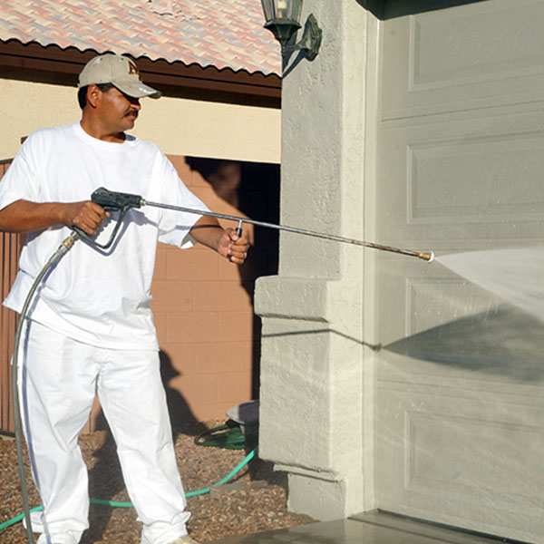 Our painter uses a pressure washer to thoroughly clean off the garage door of a home here in Phoenix, Arizona.