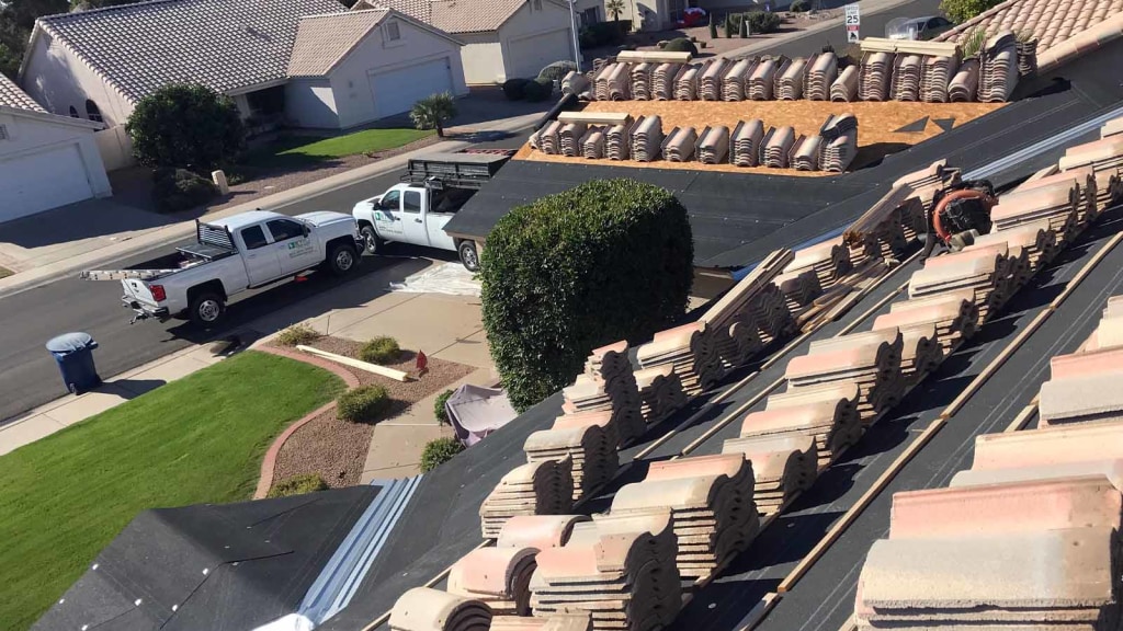 The view from a roof of a Phoenix roof replacement project, where two KY-KO trucks sit parked into the driveway.