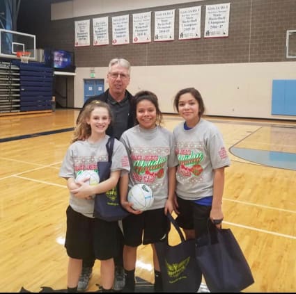 Brian Agler stands with a few of last year's campers as they hold some of their gifts for attending. Photo courtesy of Rika Powaukee.