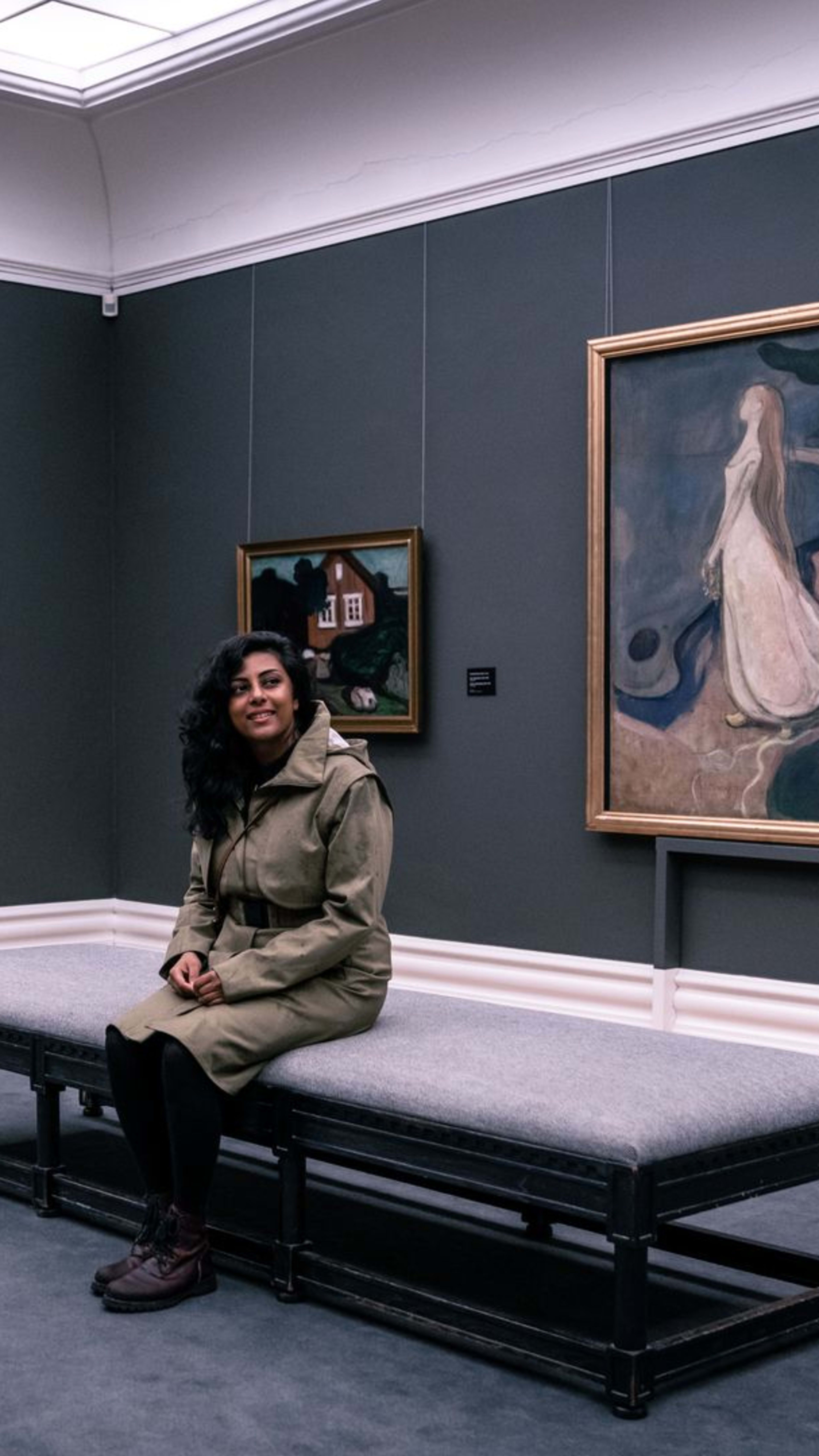 Kvinne slapper av på gallerisofaen på Kode kunstmuseum i Bergen og nyter moderne kunstutstilling