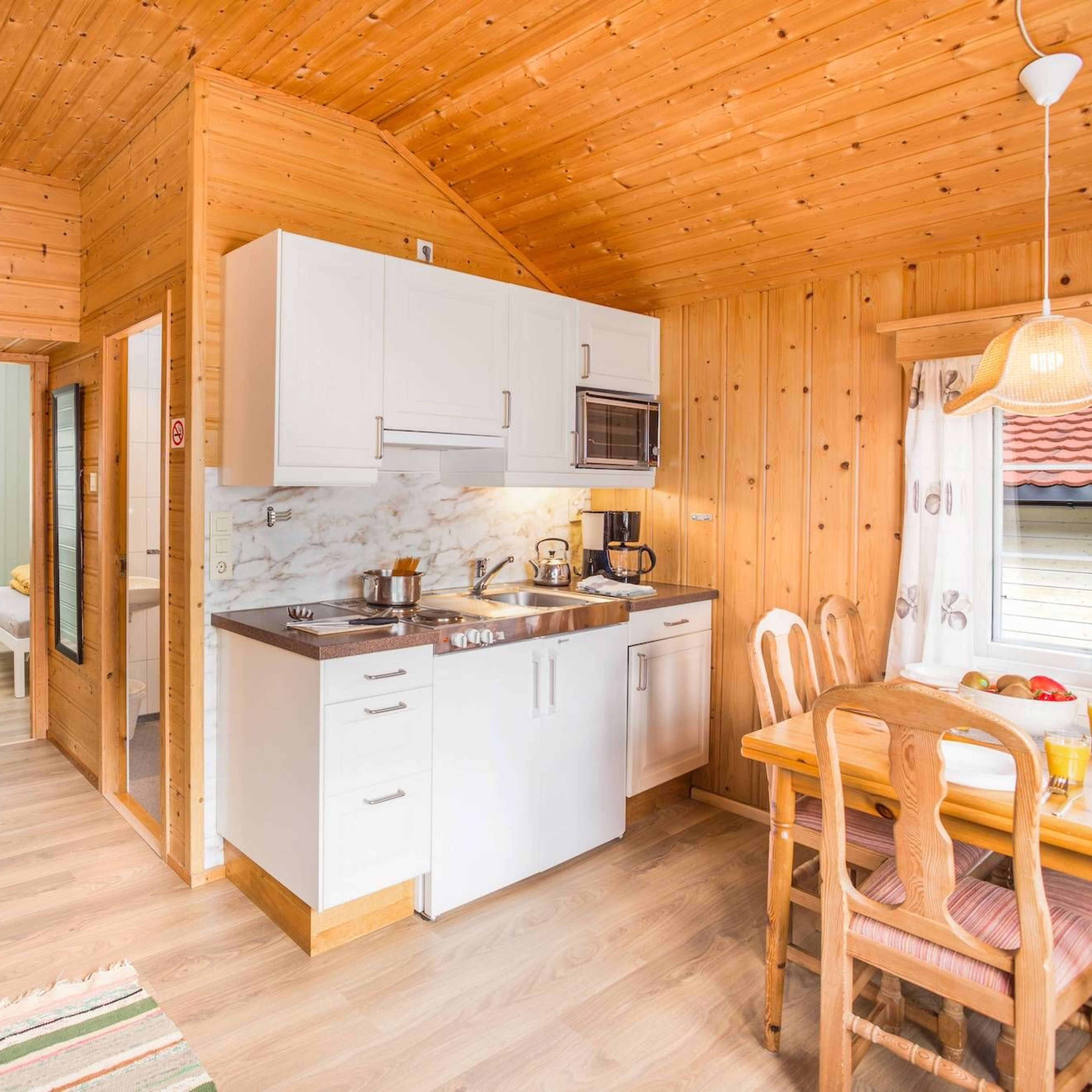 White kitchen and rooms with bunk beds in a cabin at Flåm Camping