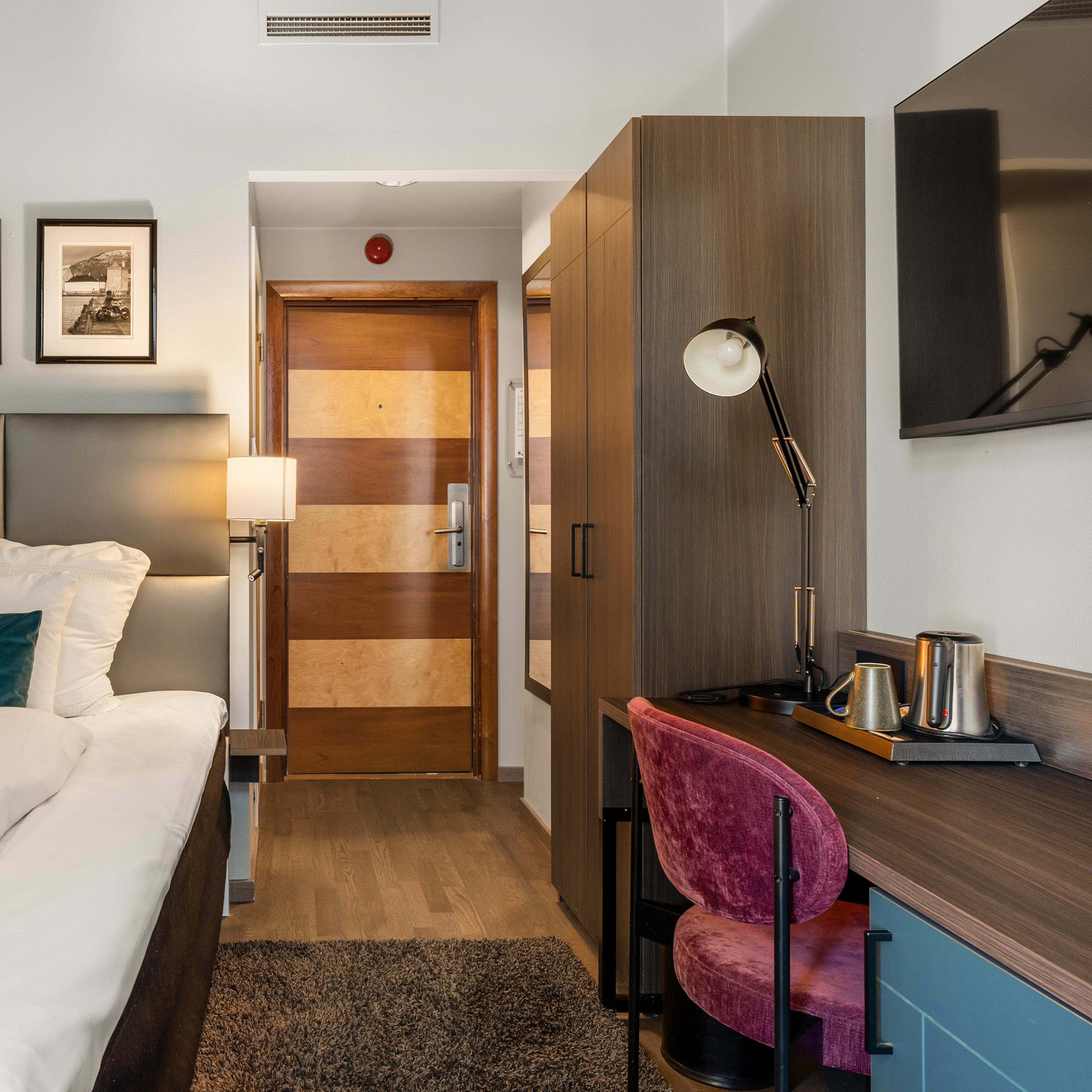 Cozy single room at Clarion Hotel Admiral featuring elegant décor, a desk, and a comfortable chair.