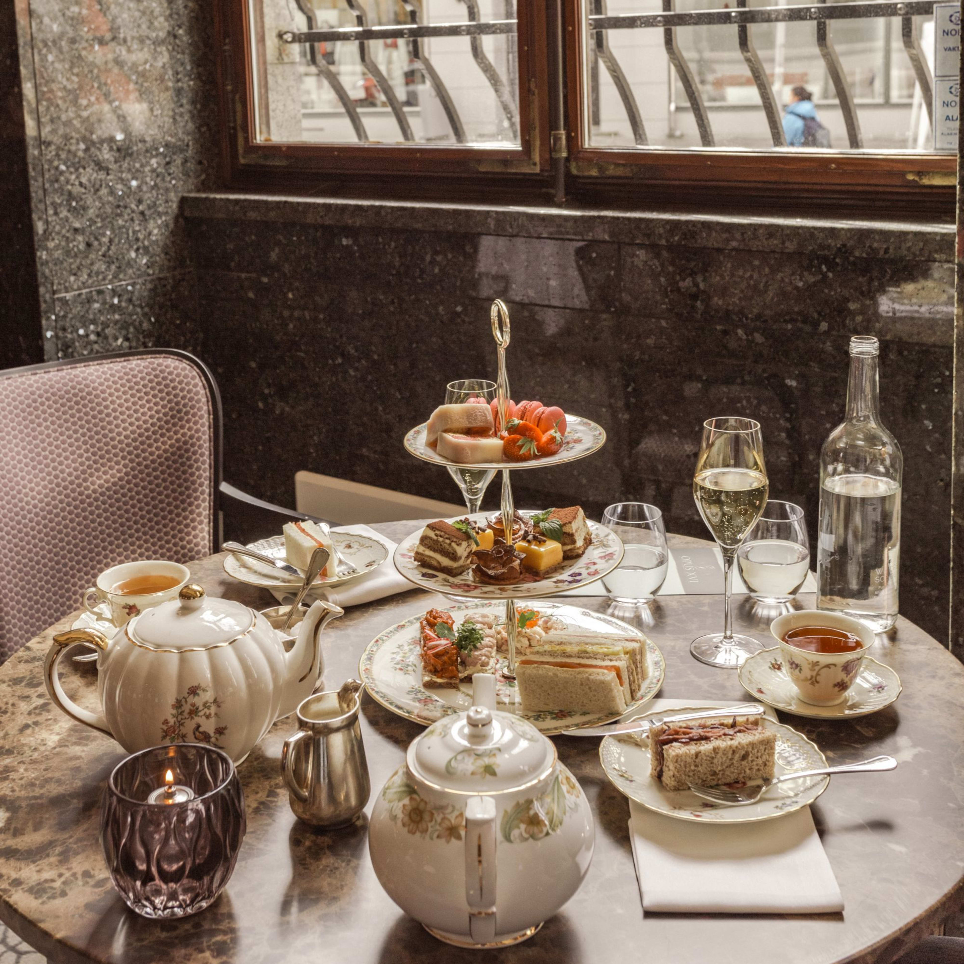 Elegant afternoon tea service at Opus XVI Hotel Bergen with artisan pastries, sandwiches and champagne in refined setting