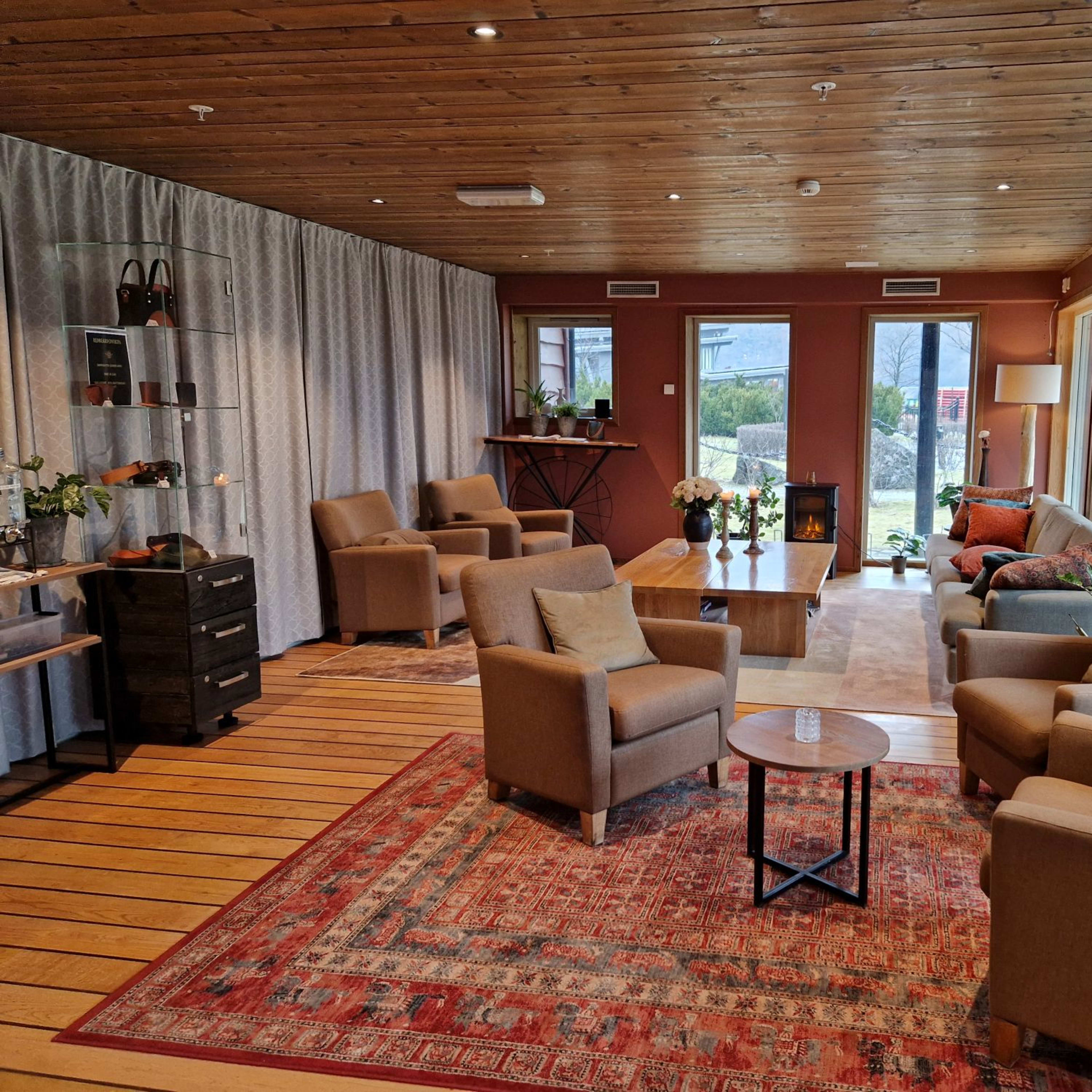 Welcoming lobby with beige chairs, coffee tables and large windows at Flåmsbrygga Hotel in Flåm