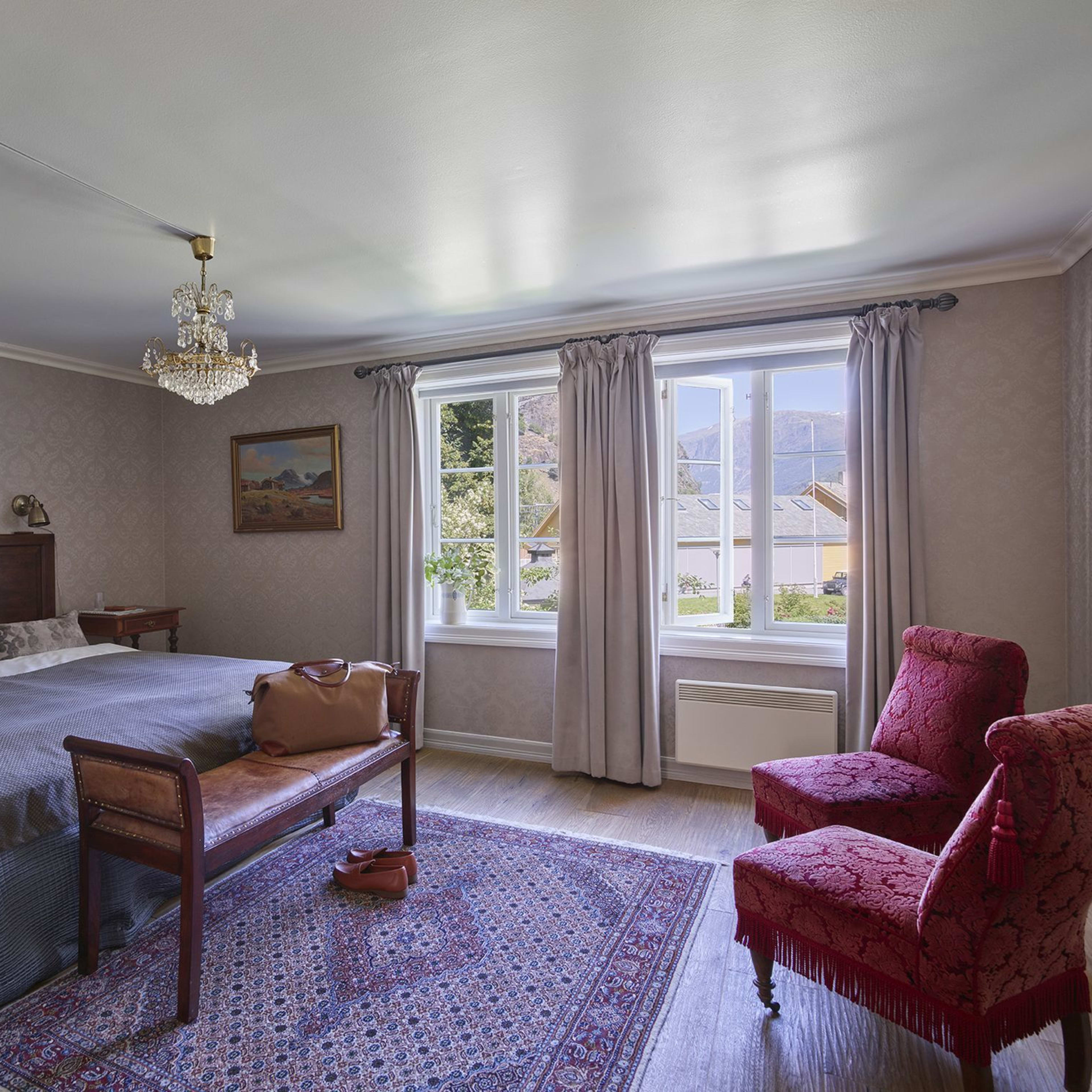 Elegant dobbeltrom på historiske Fretheim Hotel i Flåm med tradisjonell lysekrone, varm koselig atmosfære og vakker hagesutsikt
