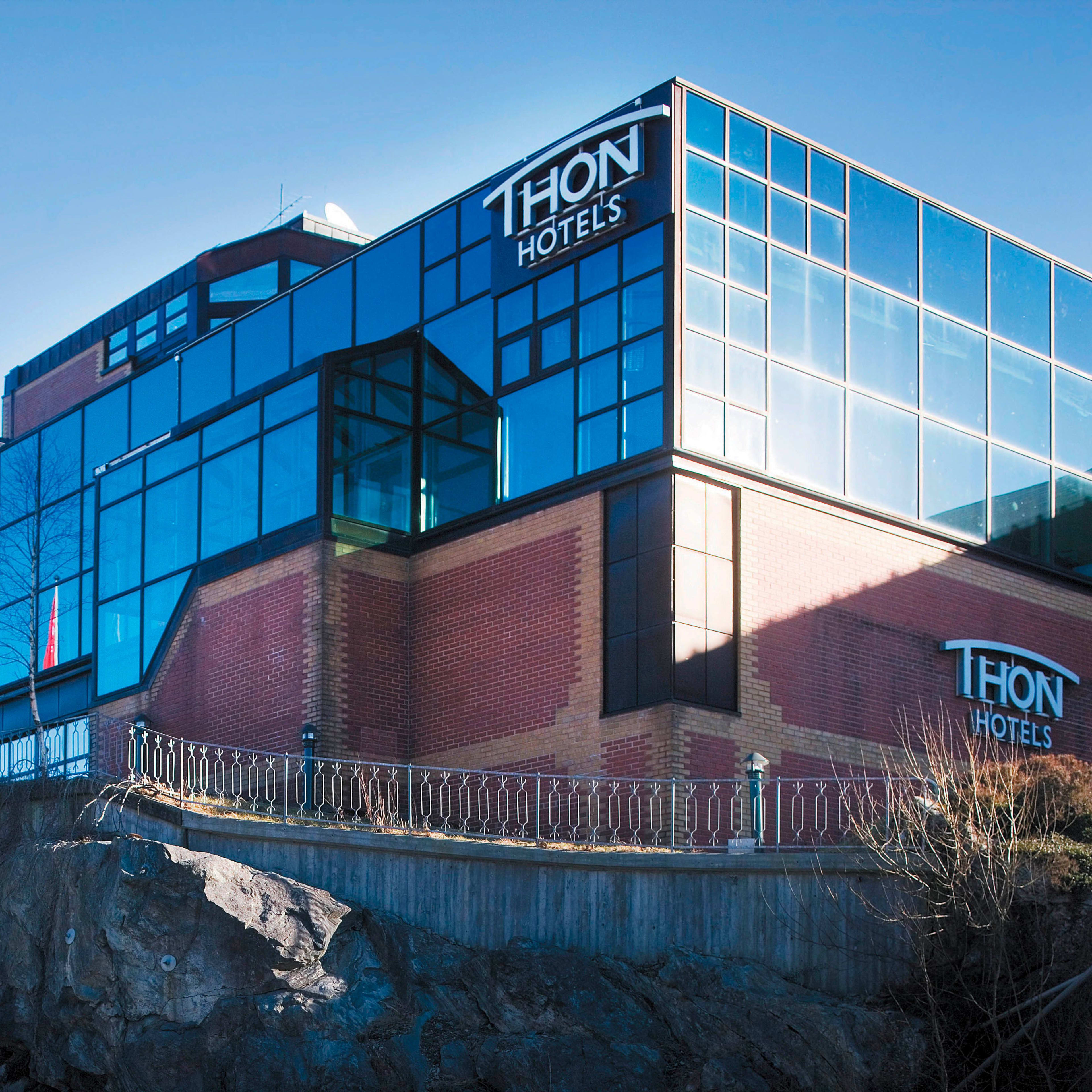 Thon Hotel Bergen Airport building exterior showing contemporary architecture with expansive glass windows, clear day