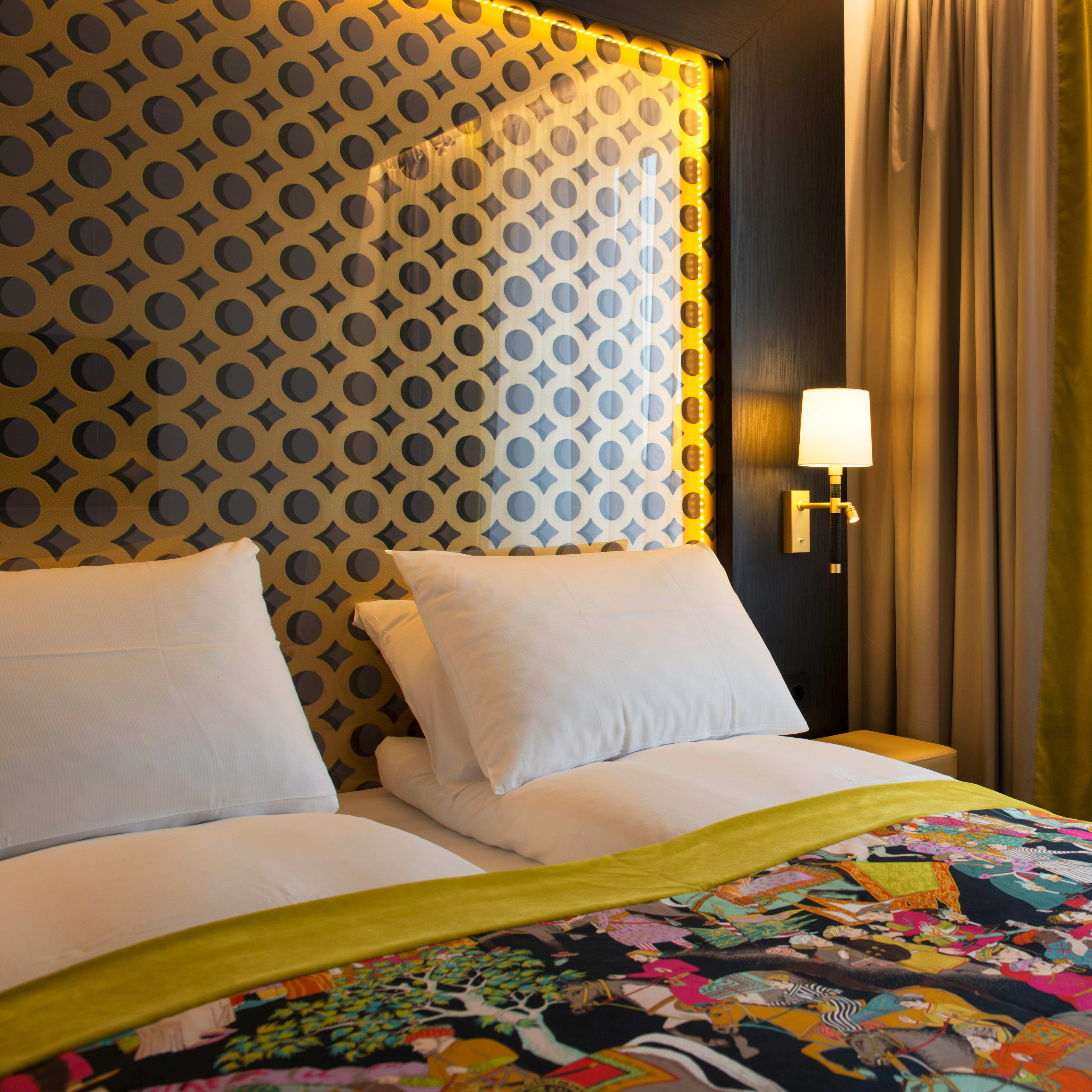 Bright double room Thon Hotel Rosenkrantz Oslo featuring floral bedding and bold yellow black polka dot walls