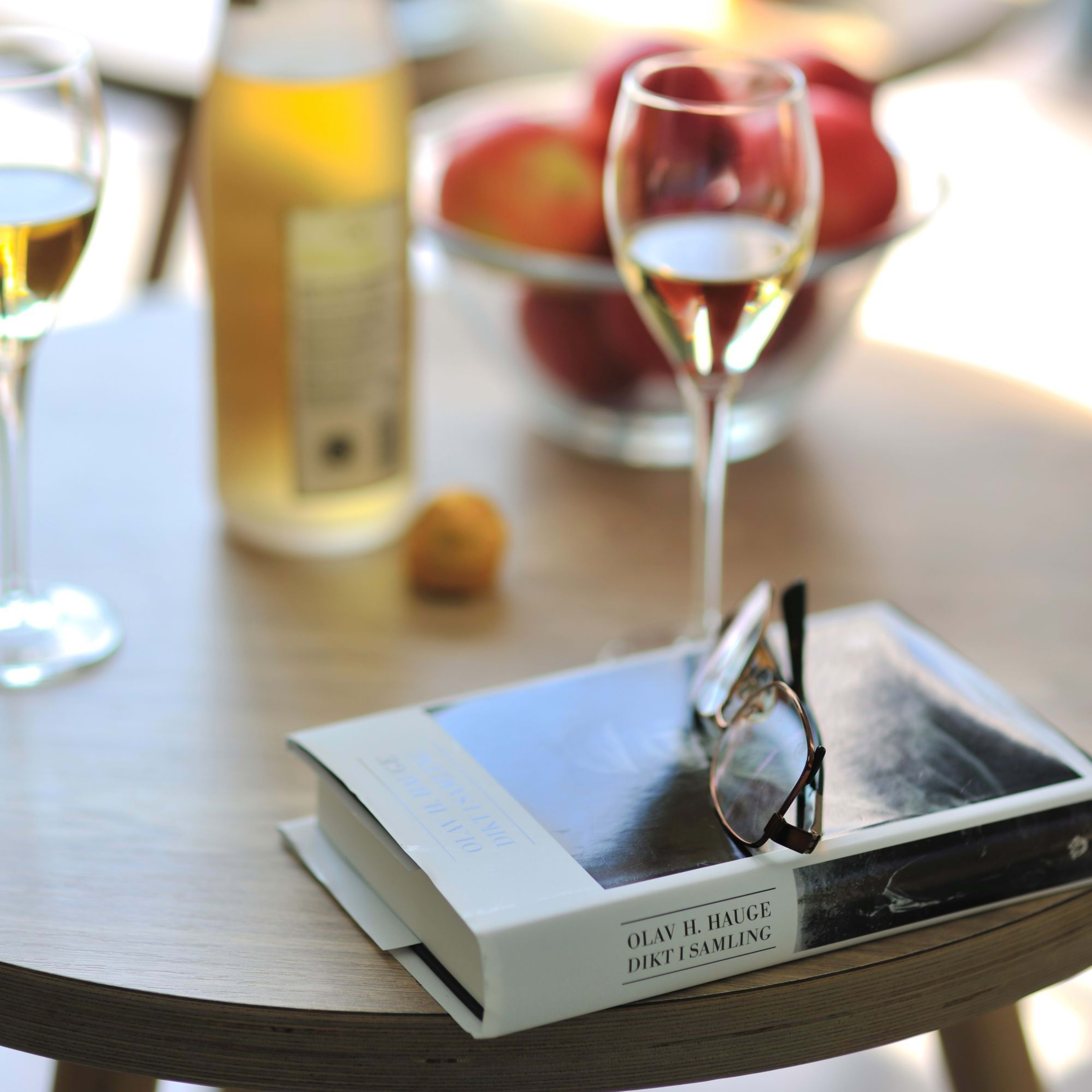 Brakanes Hotel Ulvik guest enjoying Hardanger cider and reading by Hardangerfjord