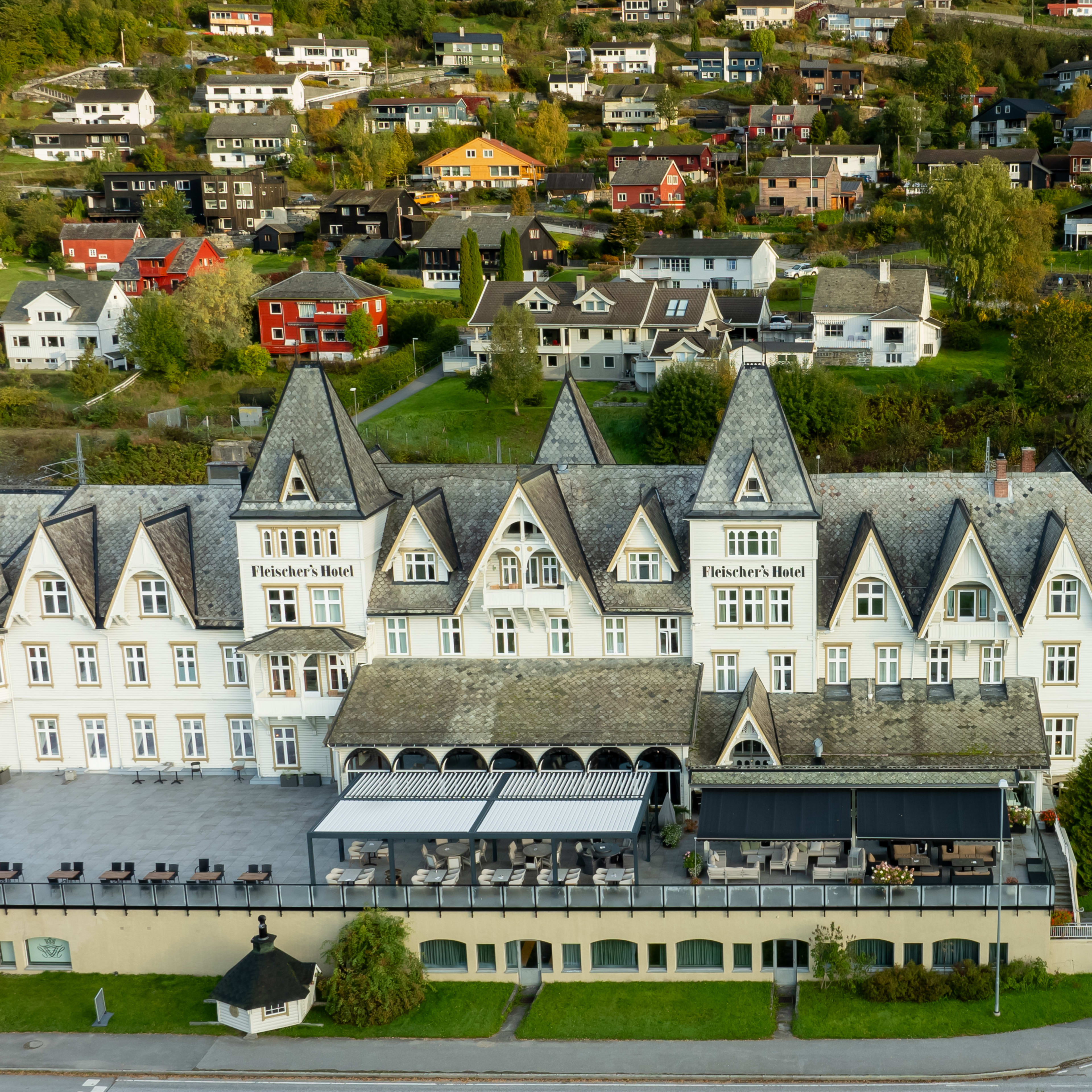 Fleischers Hotel på Voss - historisk norsk hotell med utendørs restaurantterrasse på solrik dag