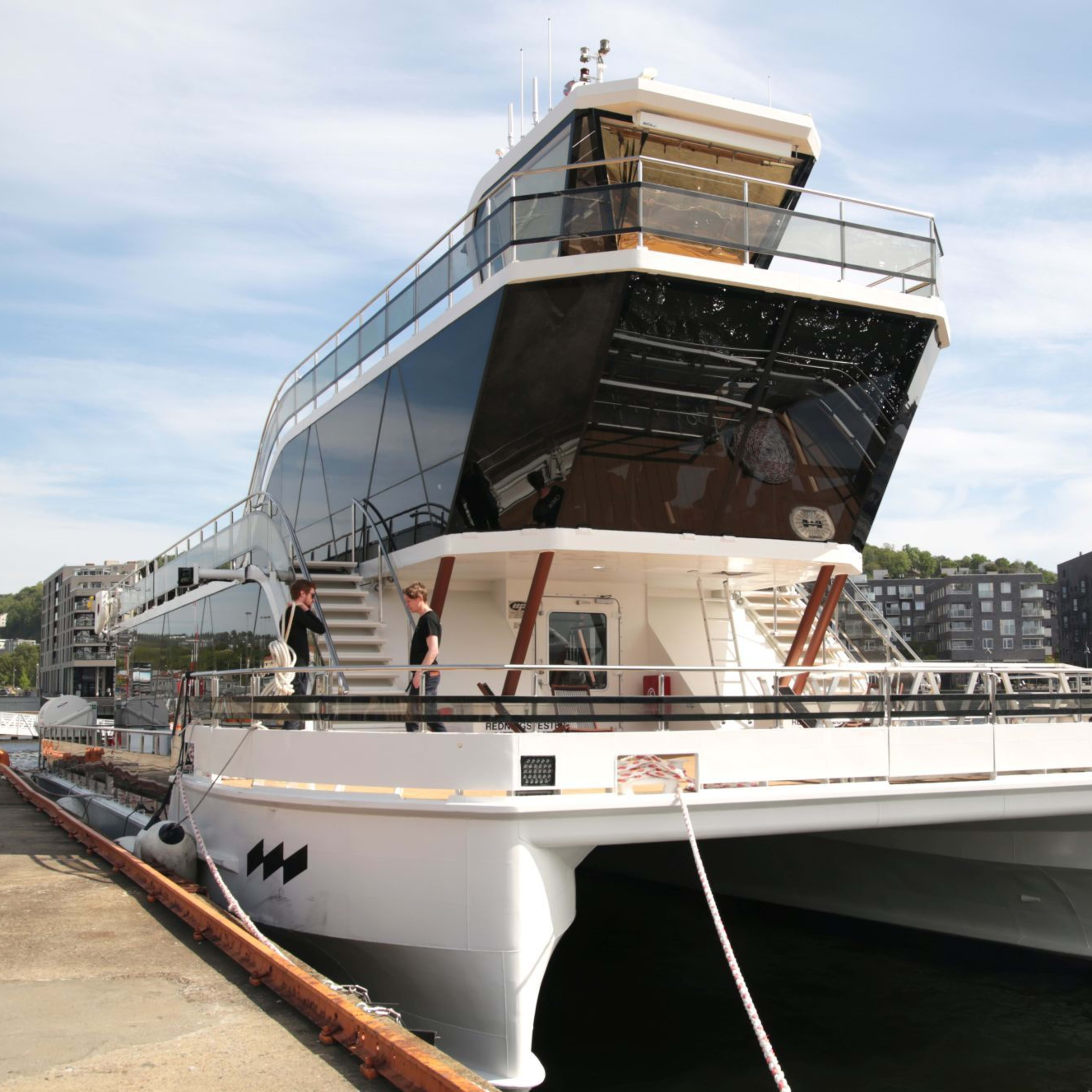 White cruise boat docked at city harbor