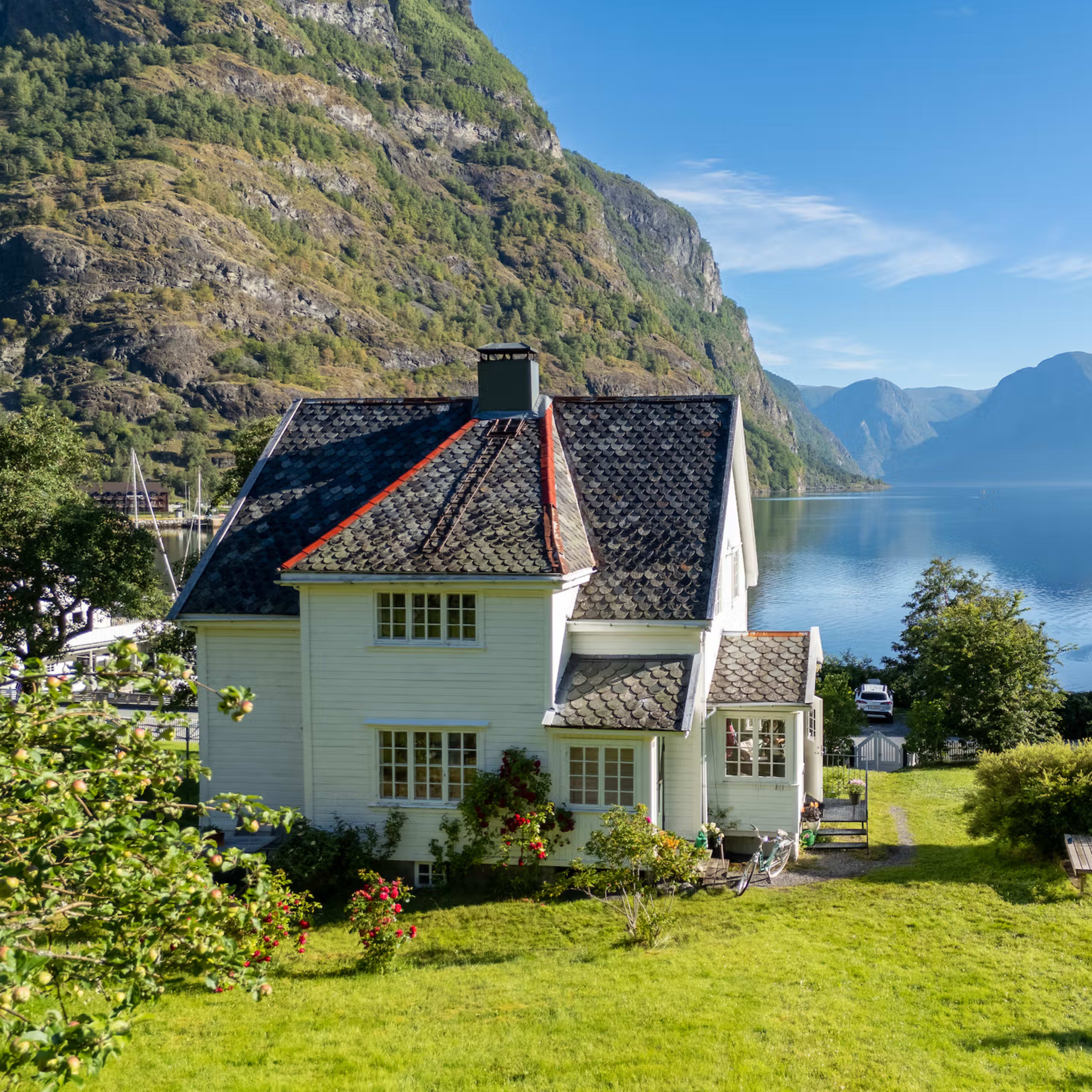 Traditional white Norwegian farmhouse in Flåm fjord valley