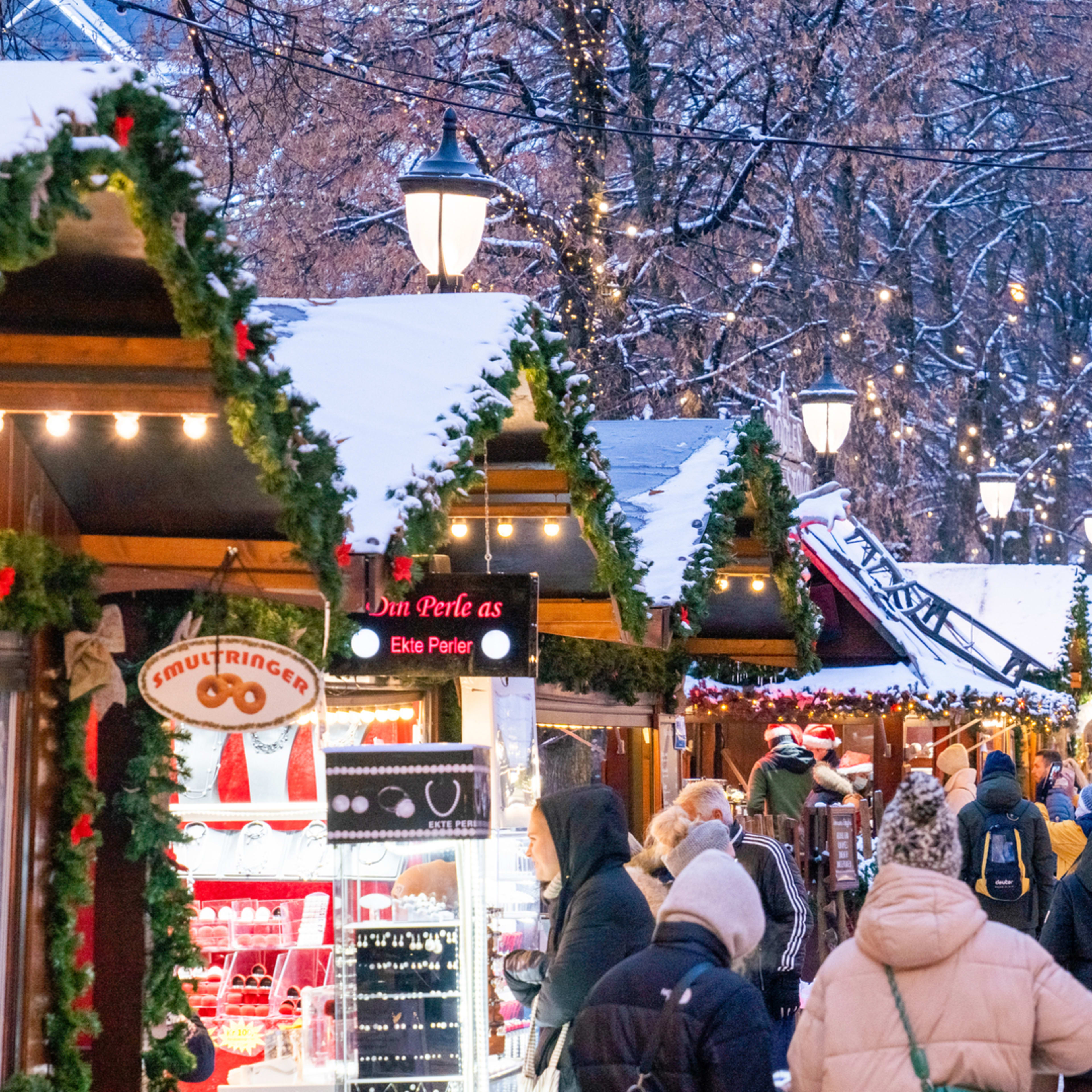 Christmas market with falling snow and festive lights in Oslo