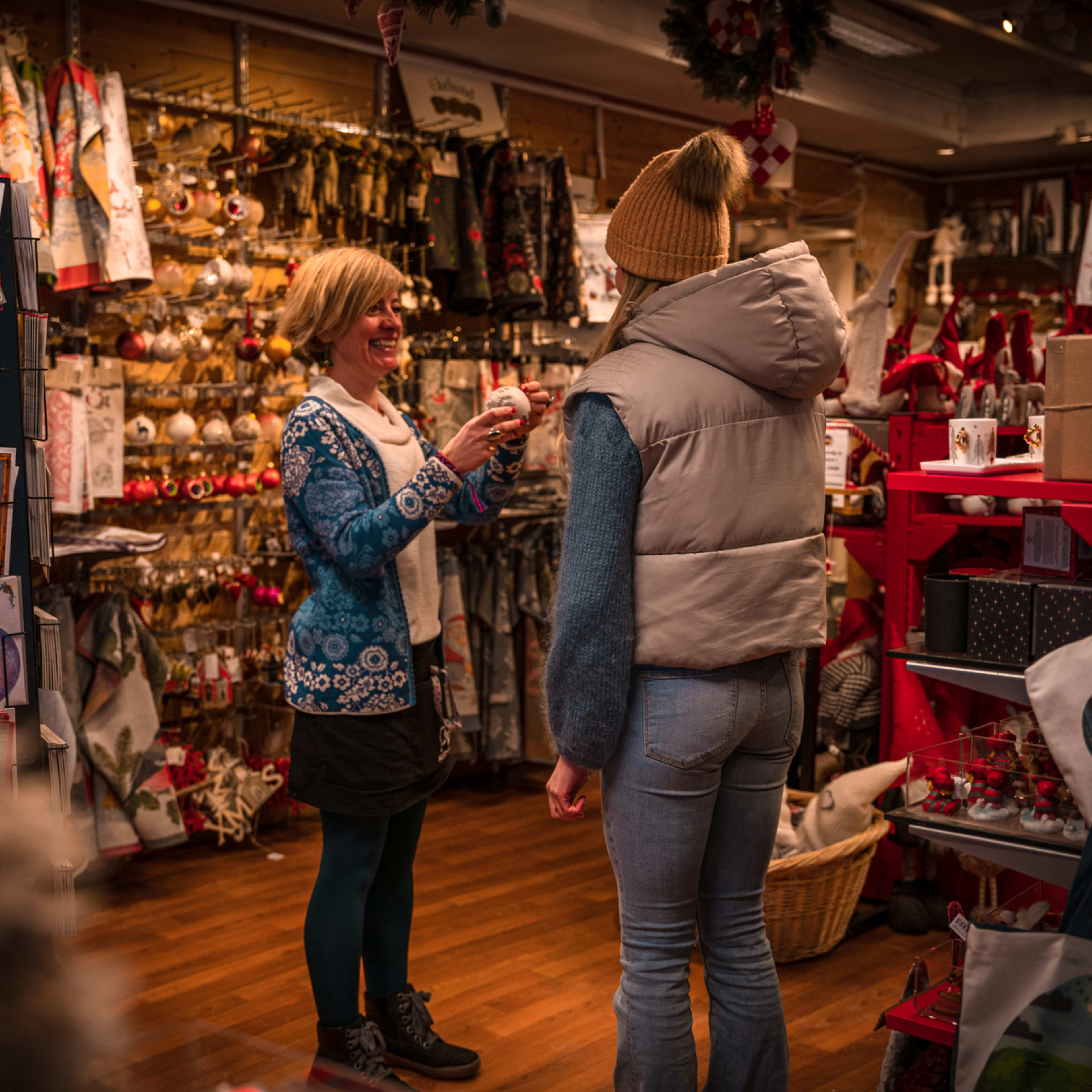 Tourists Christmas shopping in traditional wooden shop at Bryggen wharf, Bergen, Norway
