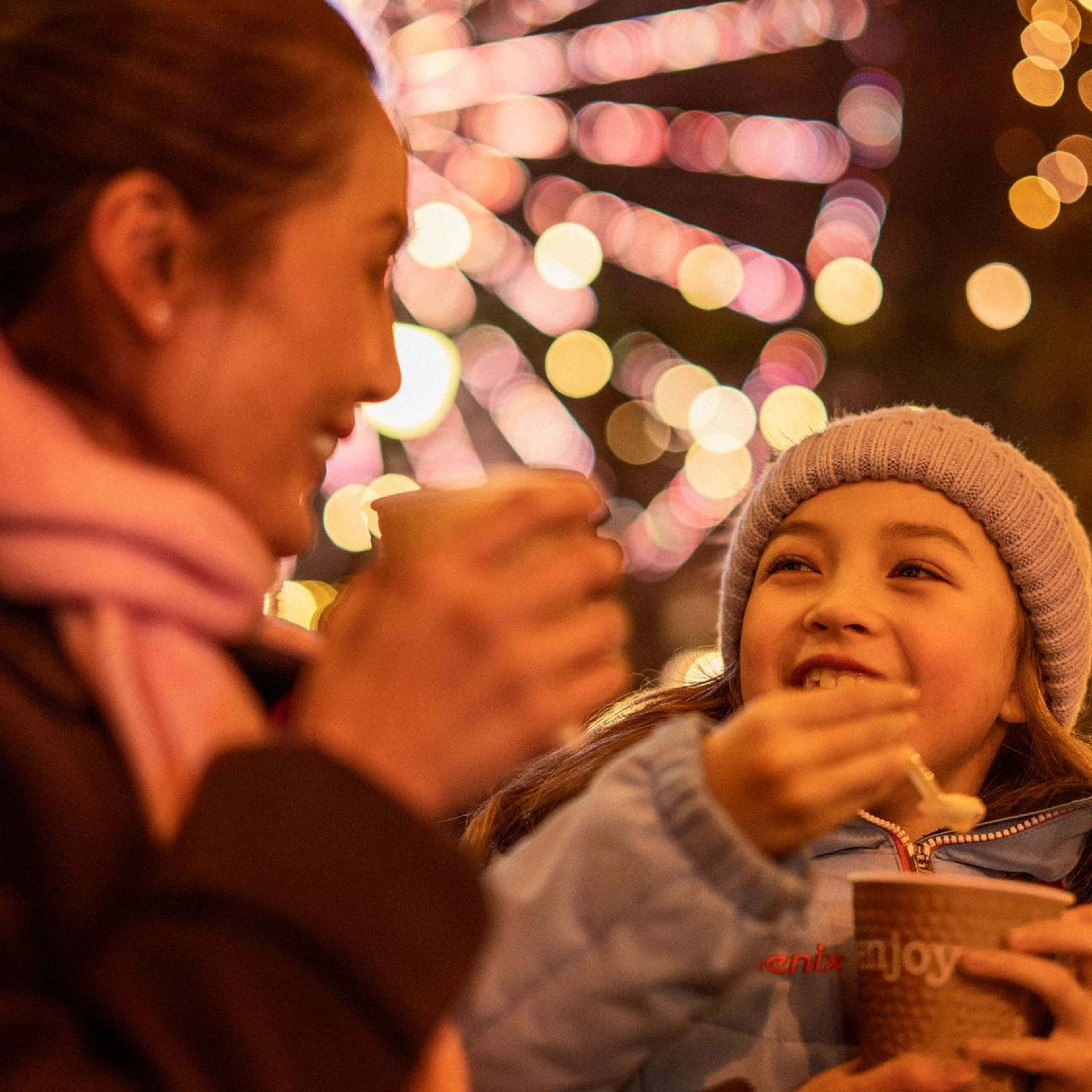 Mutter und Tochter genießen traditionellen Brei auf dem Weihnachtsmarkt in Oslo