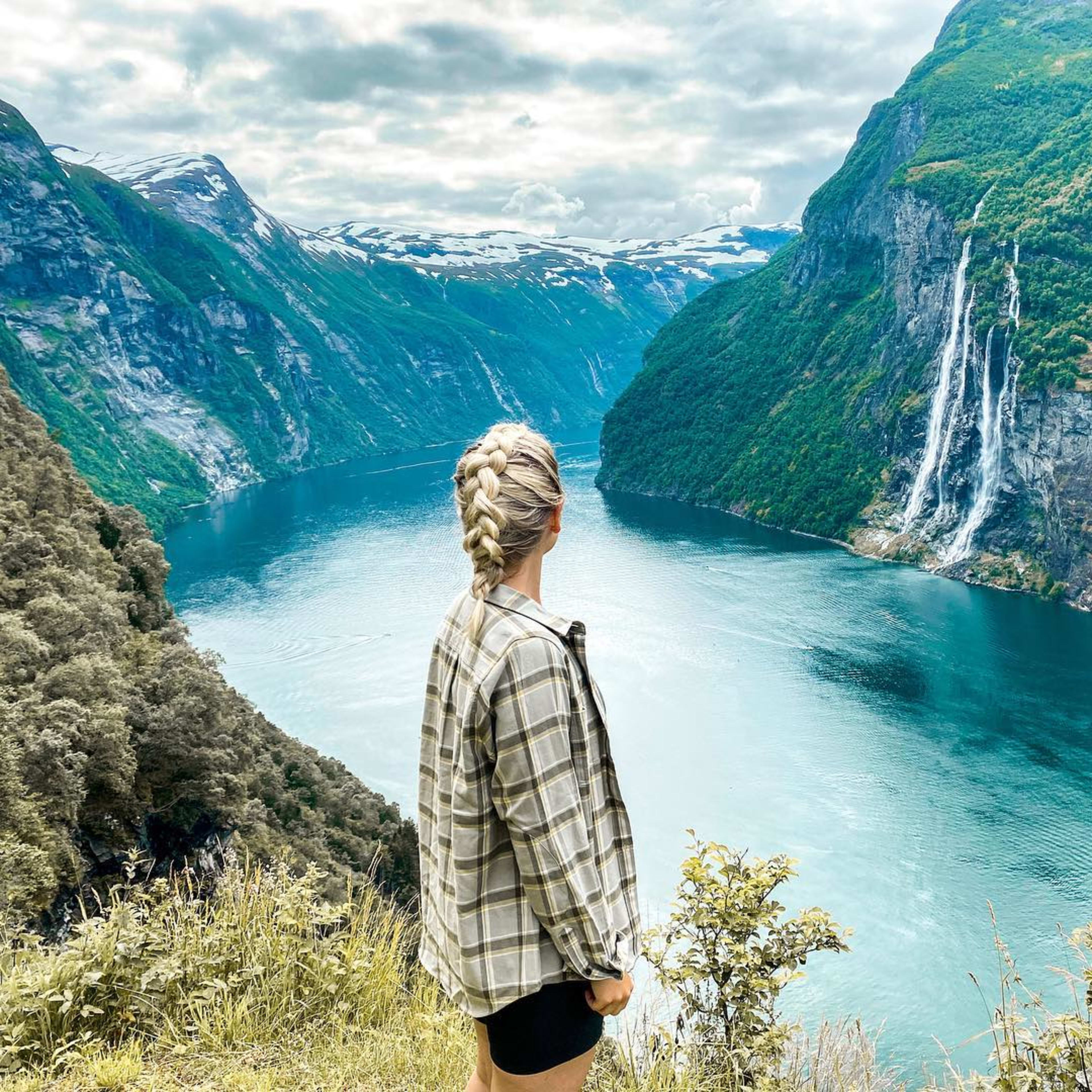 Kvinne nyter utsikt over De syv søstre fossene i Geirangerfjord UNESCO verdensarv, Norge sommer