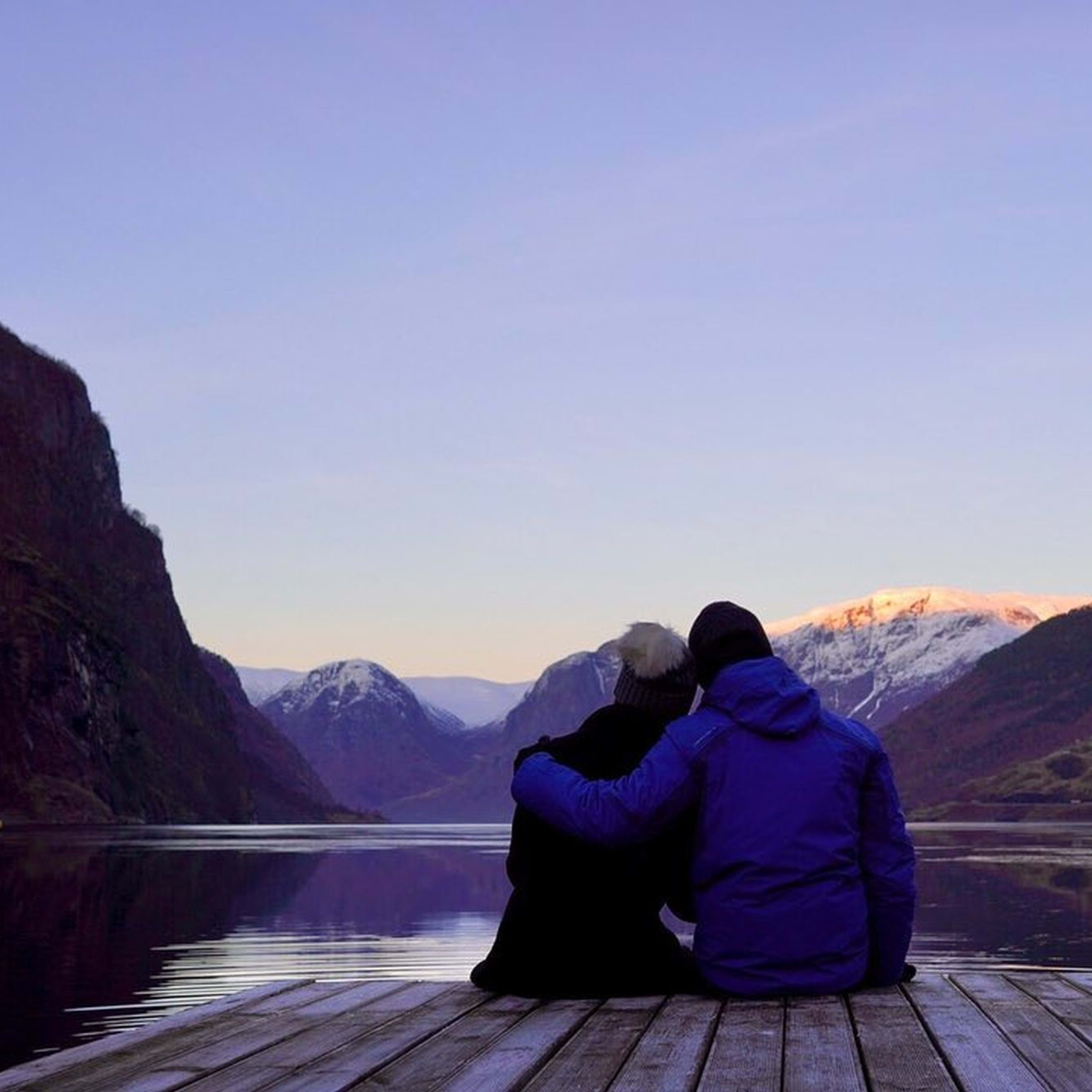 Romantisk blåtime ved Gudvangen havn - par nyter UNESCO-listede Nærøyfjorden med dramatiske vinterfjell