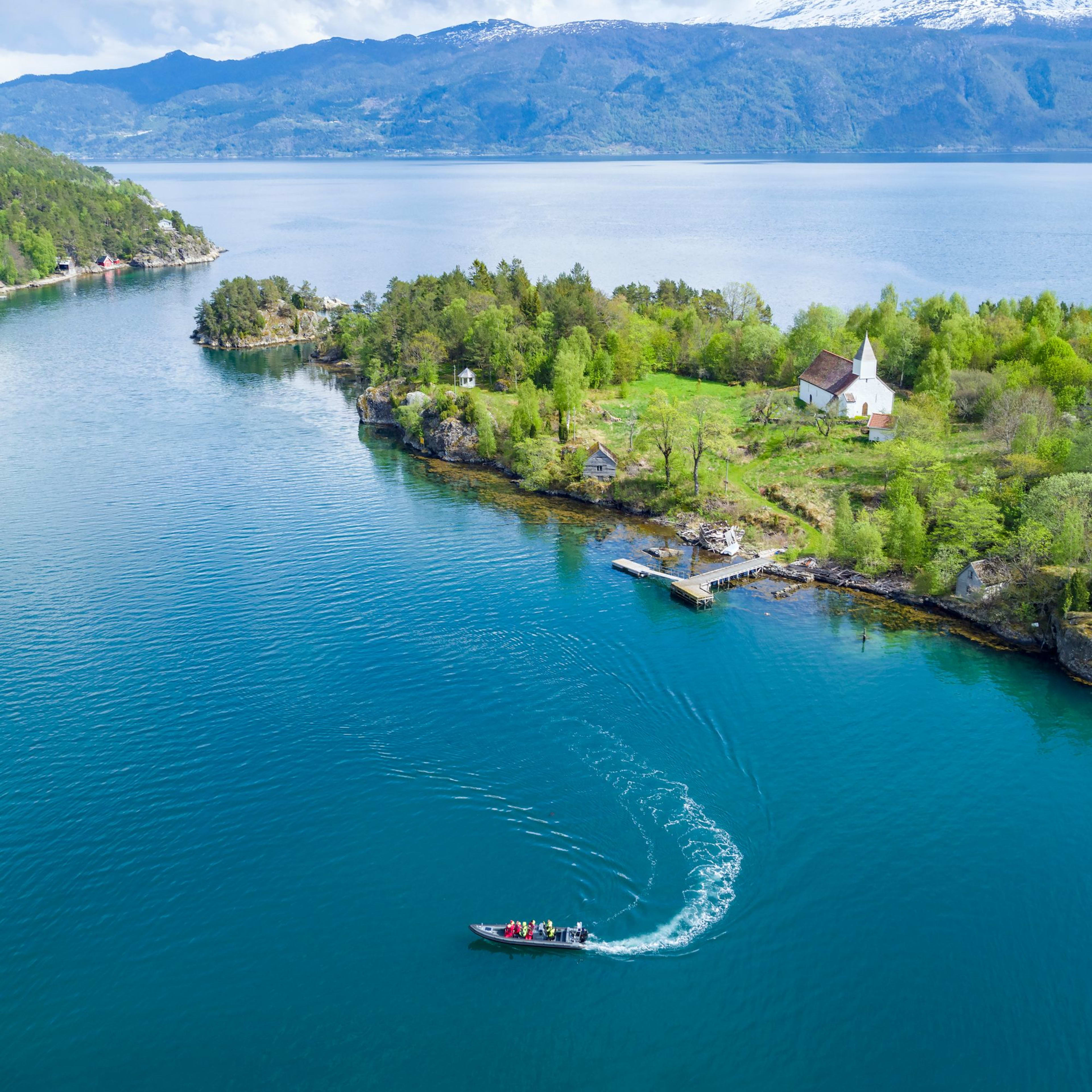Aerial view of Finnabotn with white church and RIB boat on the Sognefjord.
