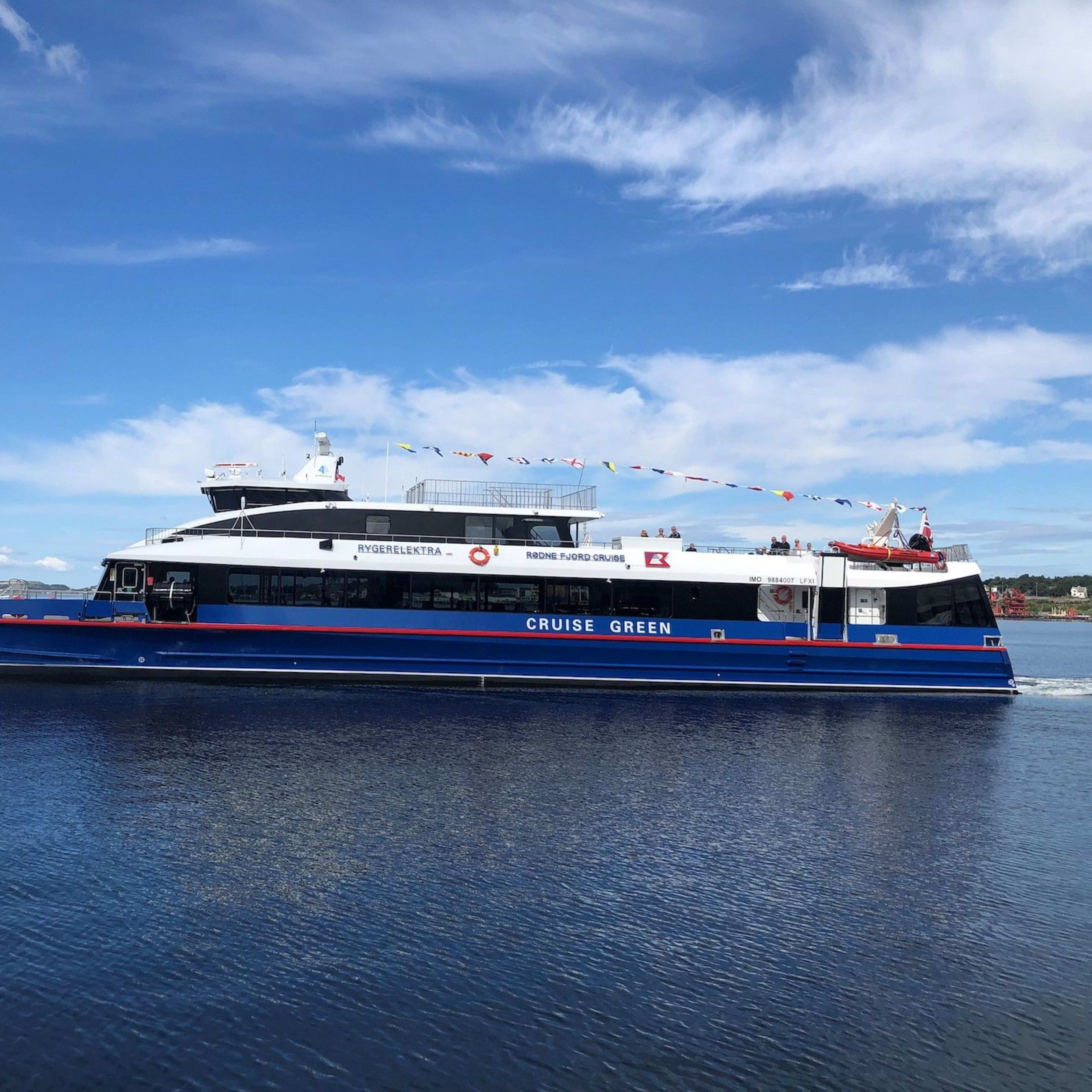 Elektrisches Boot fährt ruhig, Stadt im Hintergrund.