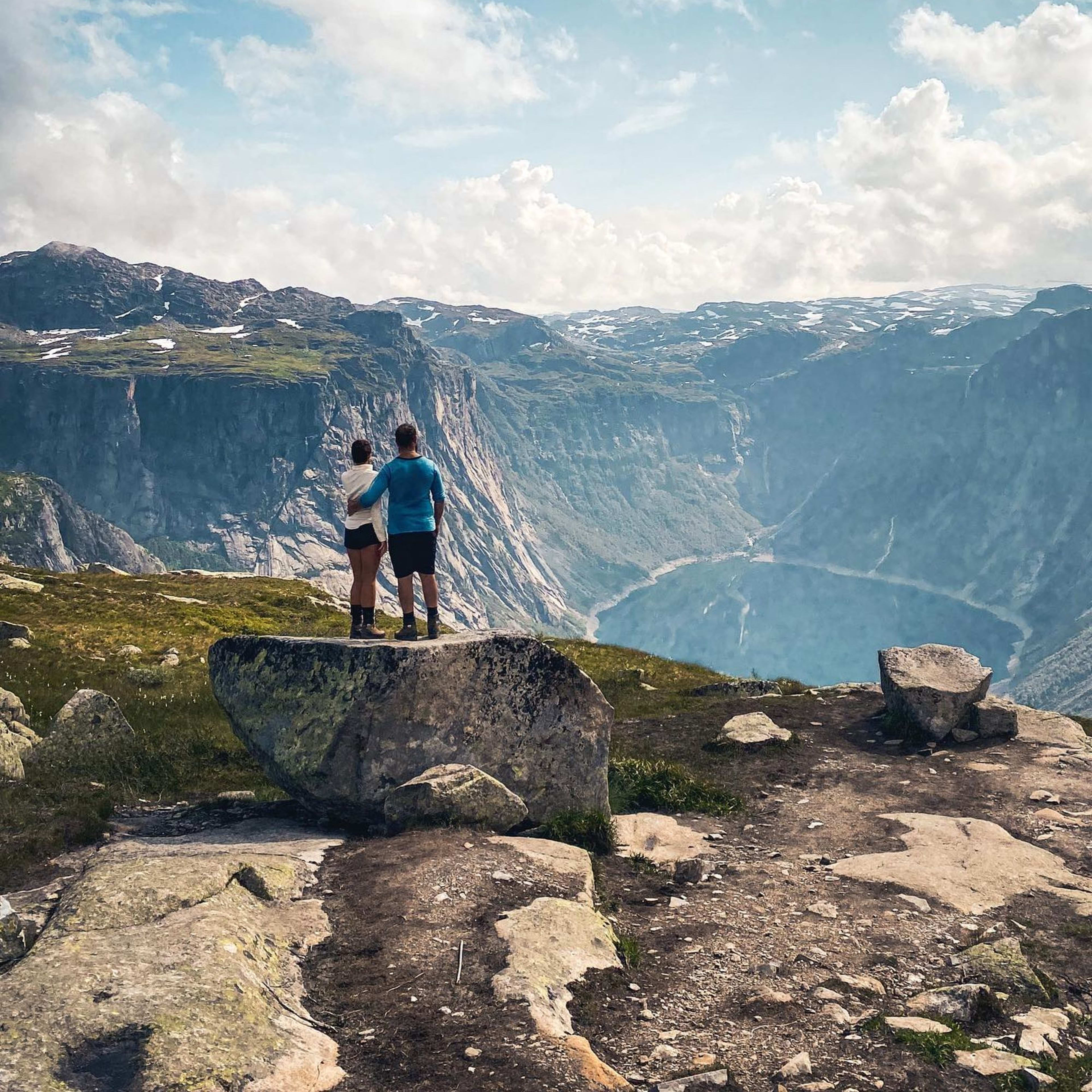 Couple on their way up to Trolltunga taking a break to enjoy the view of the surrounding landscape