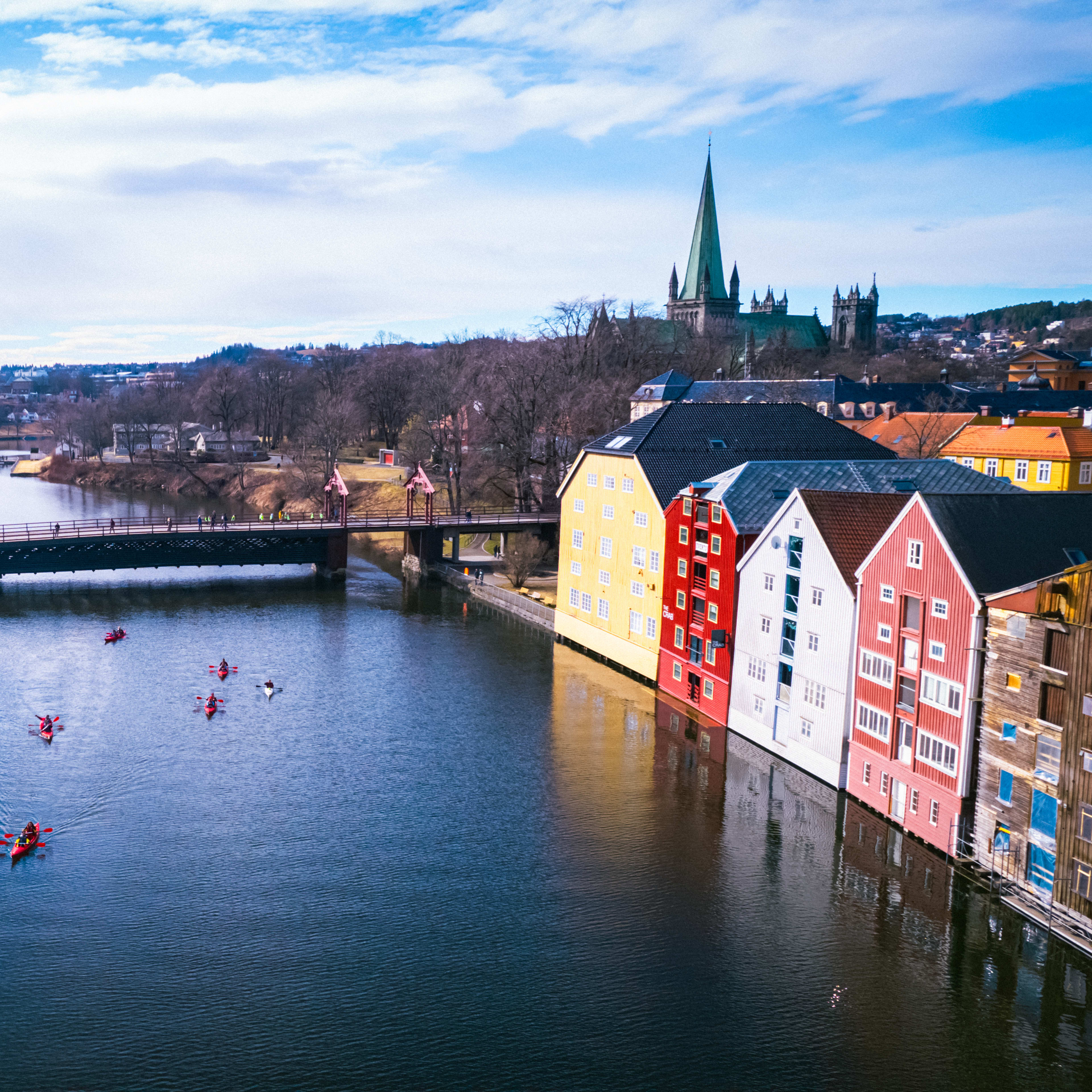 Geführte Kajaktour auf dem Nidelva in Trondheim mit Nidarosdom und bunten Ufergebäuden an einem sonnigen Sommertag