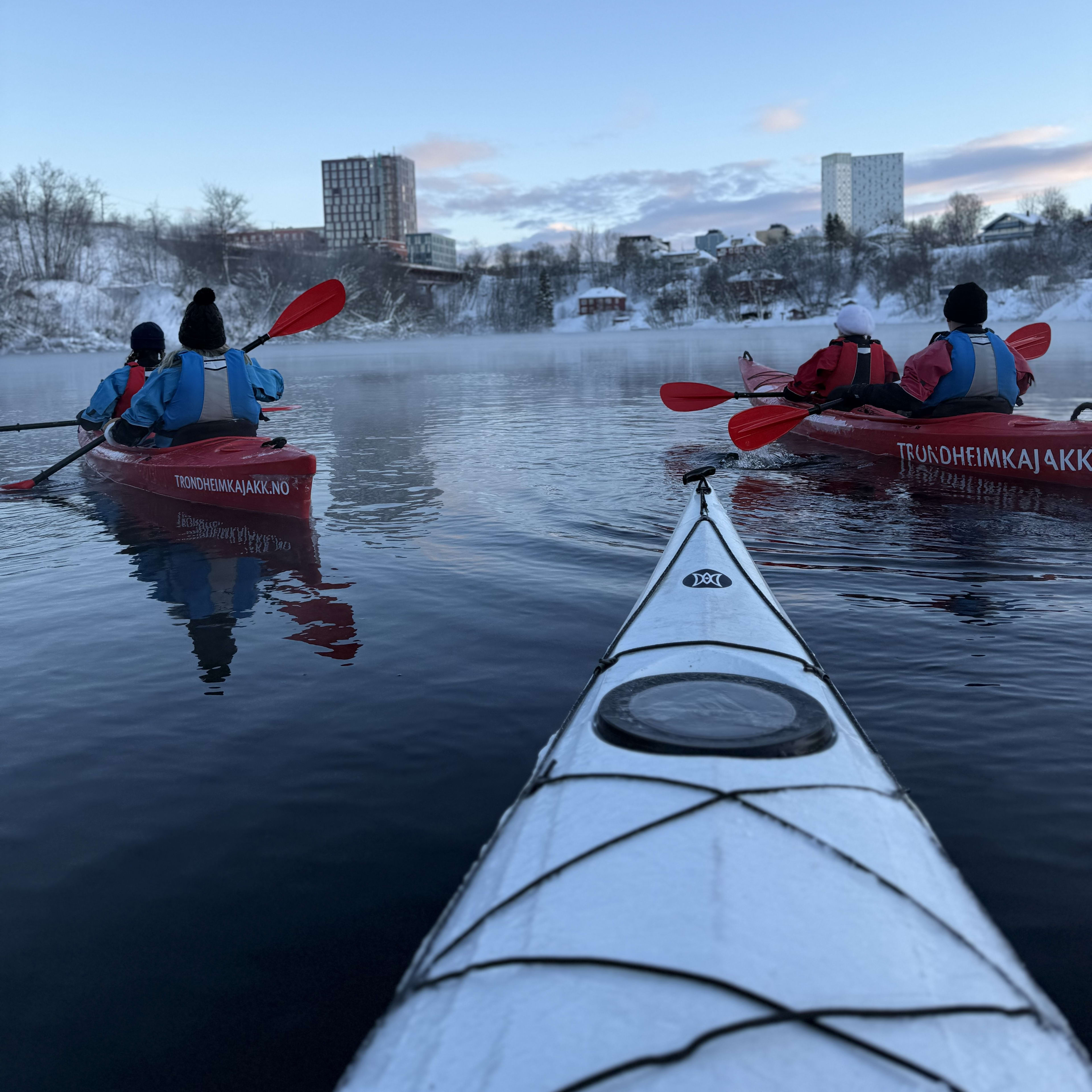 Geführte Winter-Kajaktour entlang Trondheims farbenfrohen Hafengebäuden mit schneebedeckter Uferpromenade