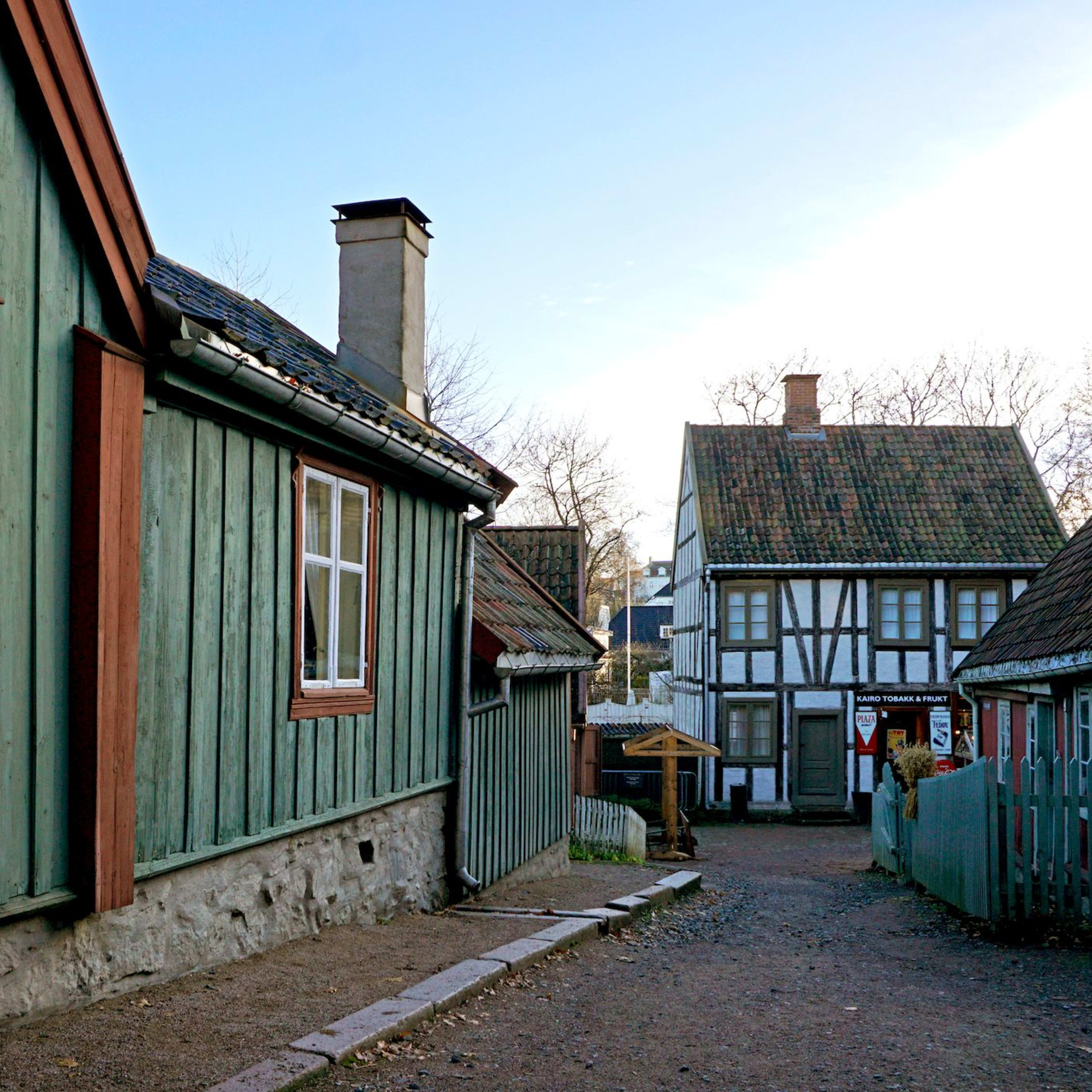 Sjarmerende bygategate med fargerike trehus, hvite vinduer og bindingsverkshus.