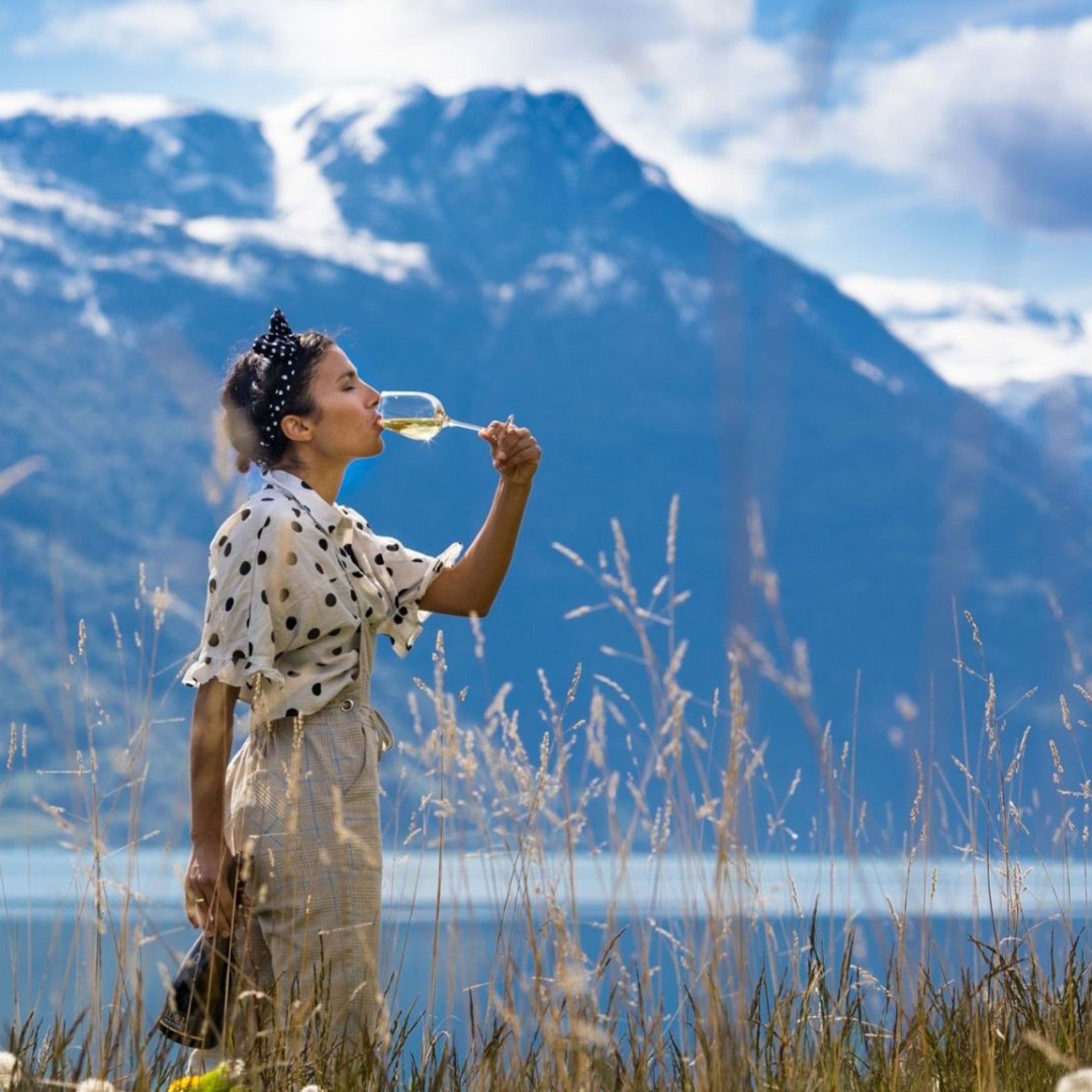 Frau trinkt Apfelwein in Ulvik mit Seepanorama.