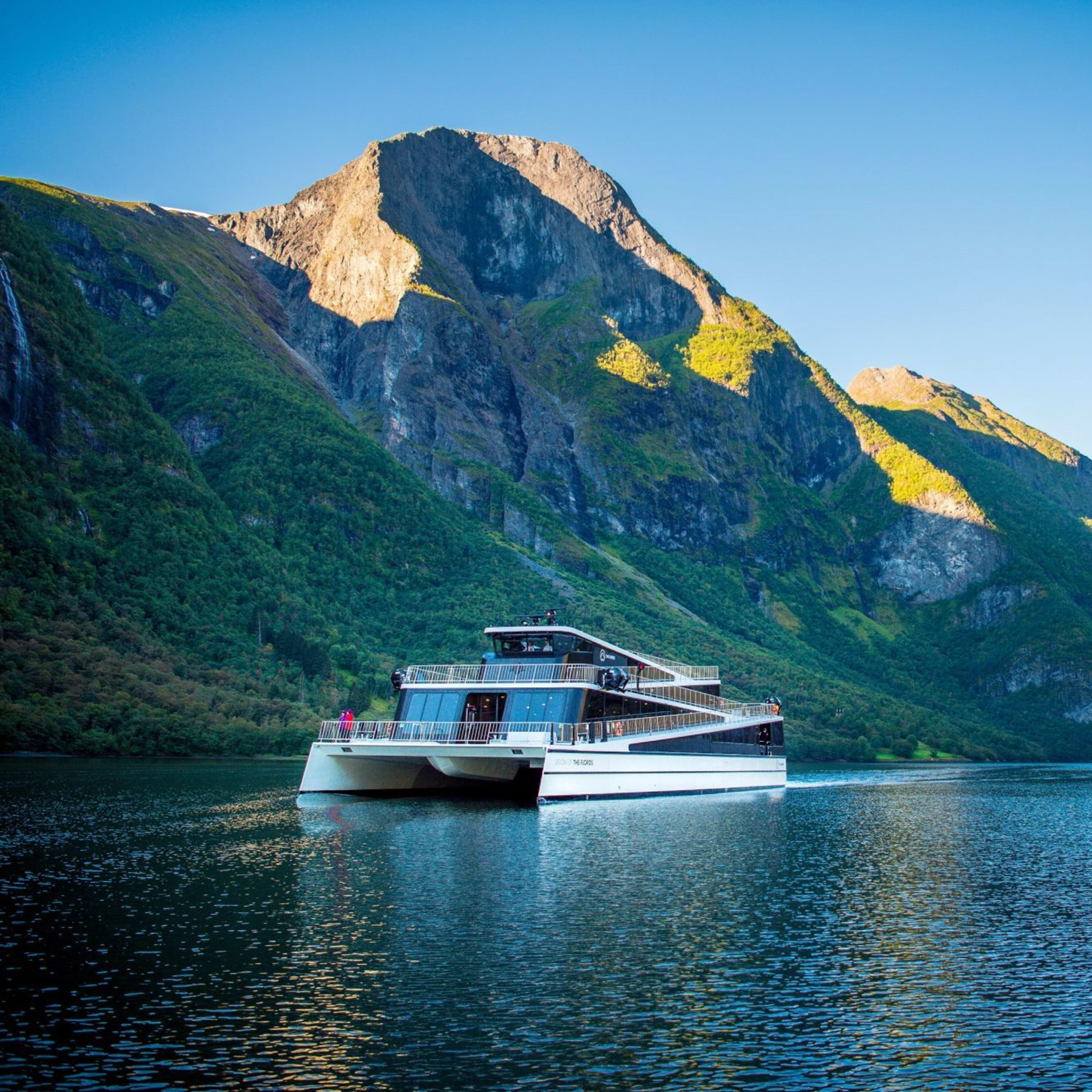 Vision of the fjords sails through the calm Nærøyfjord under green mountain walls.