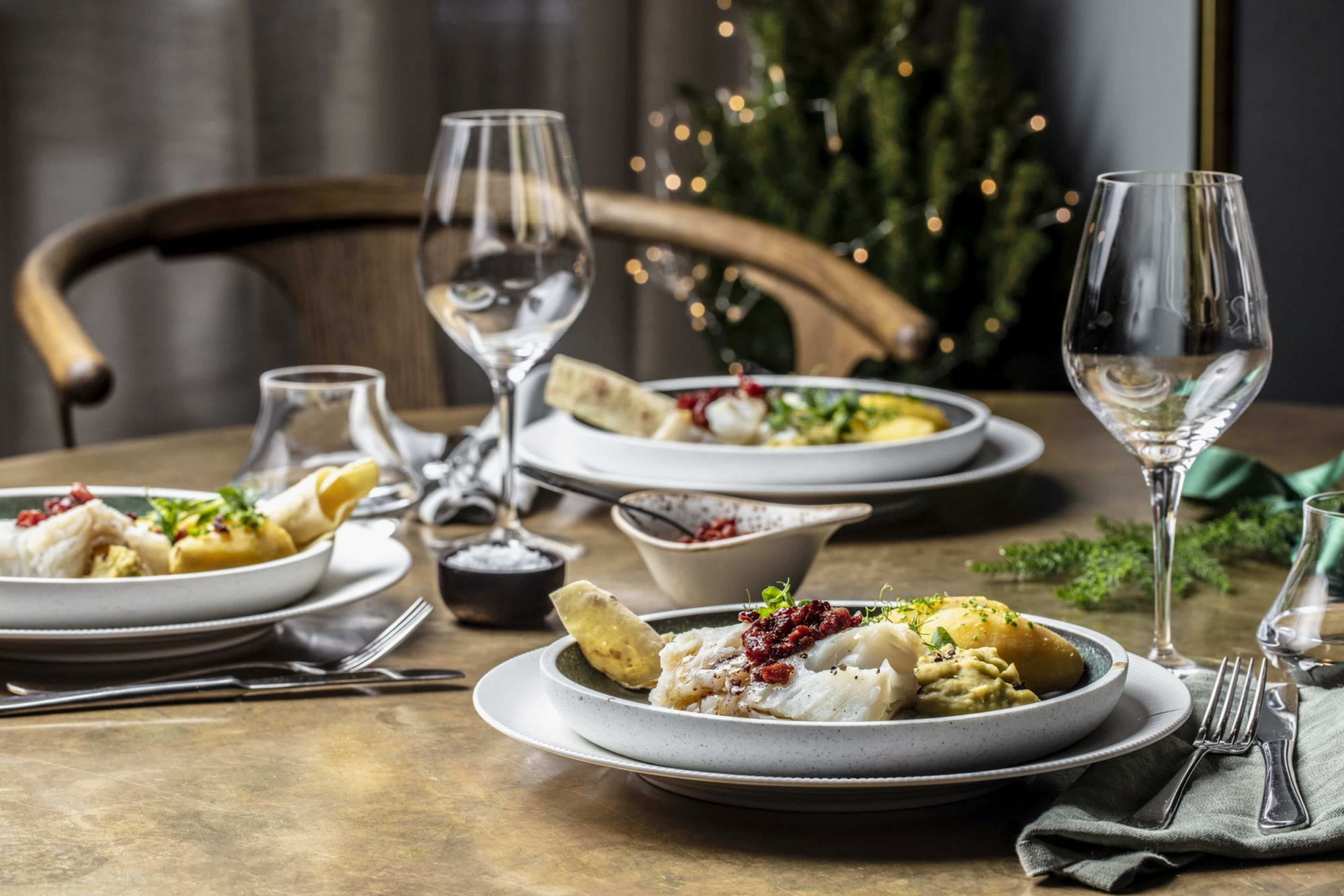 Ein festlich gedeckter Tisch mit nordischer Kost und festlicher Beleuchtung.