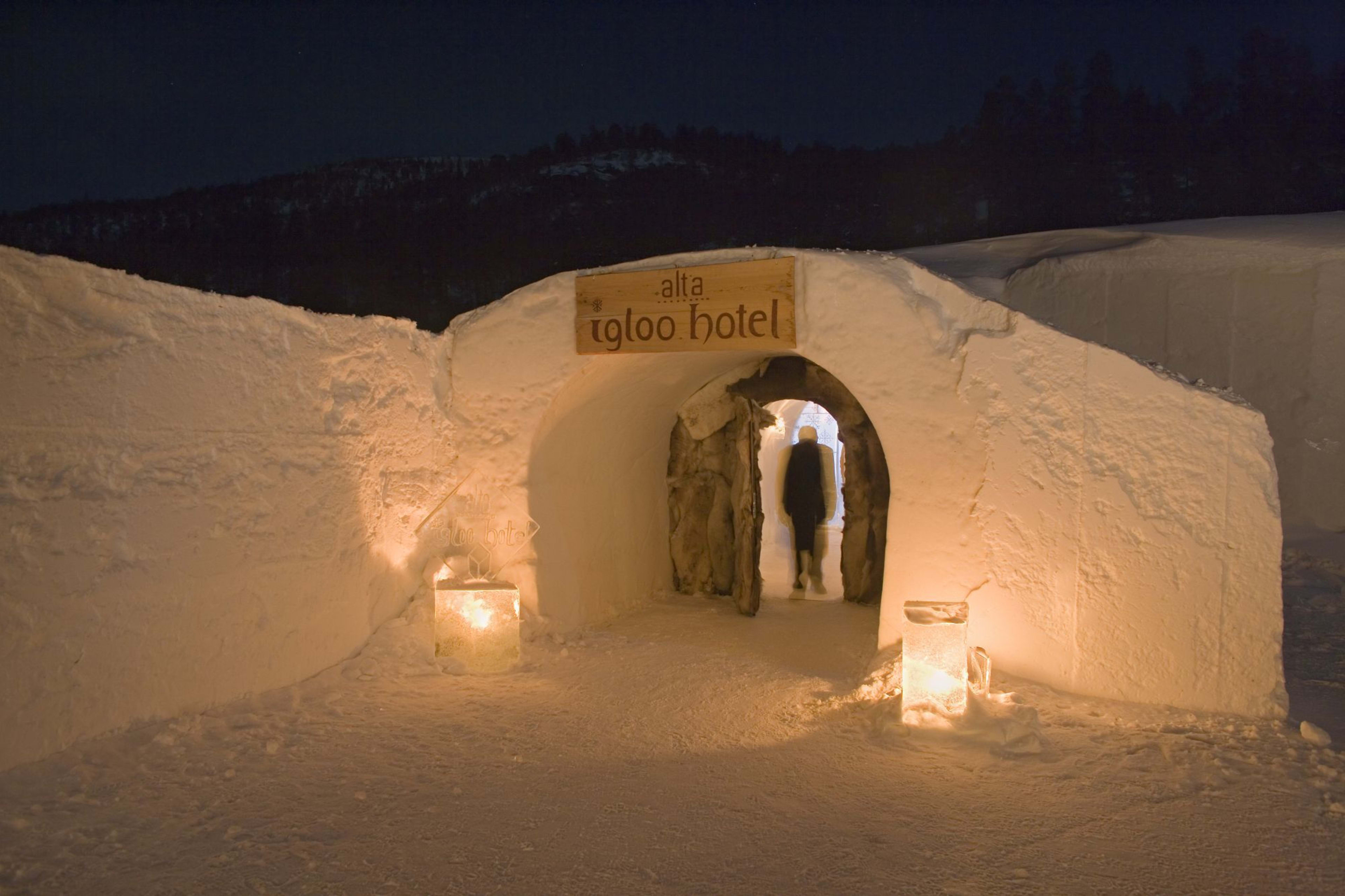 Eingang zum Alta Igloo Hotel aus Eis und Schnee, mit sanfter Beleuchtung und ruhiger, verschneiter nächtlicher Atmosphäre.