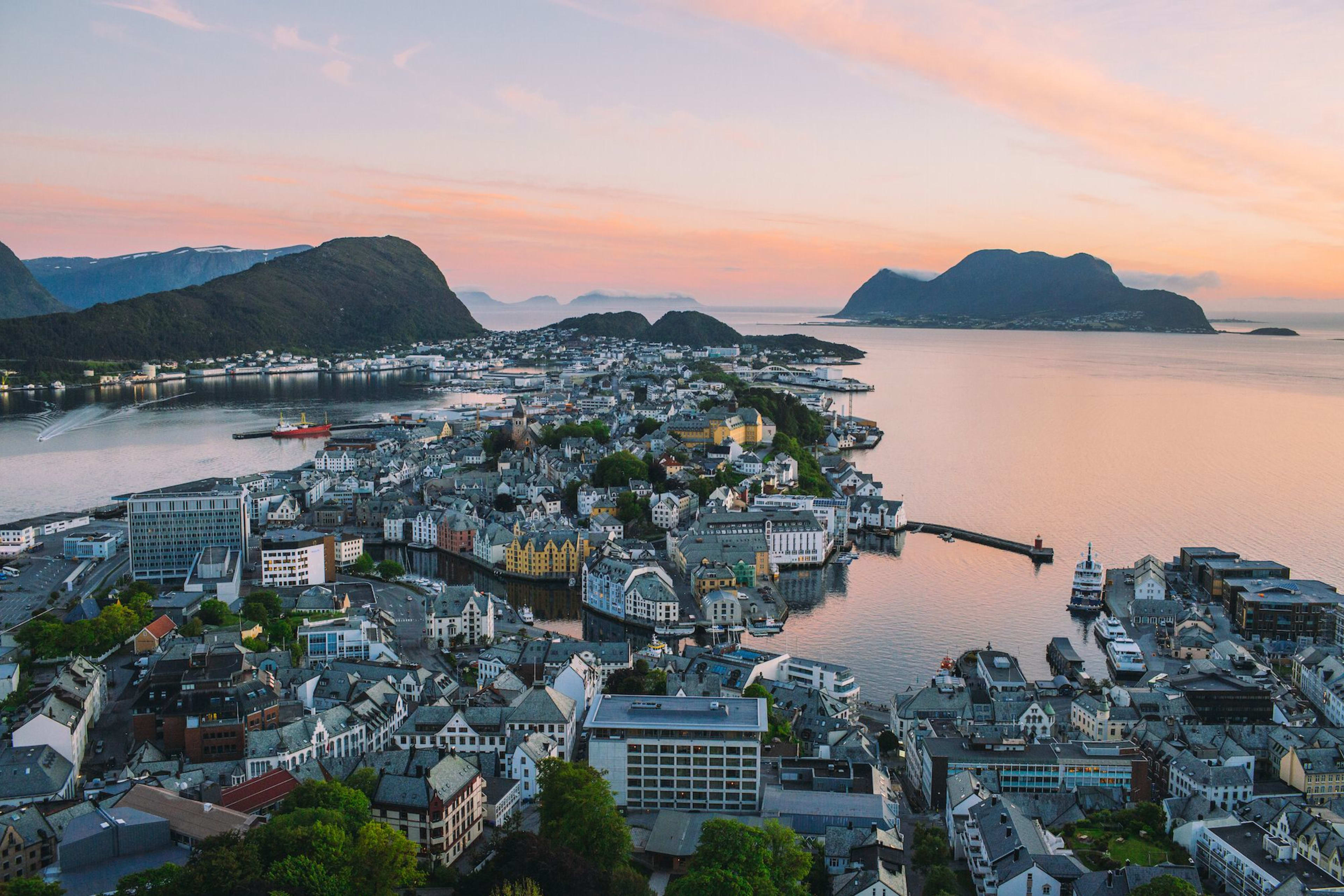 Ålesund Art Nouveau architecture at sunset with pink sky over historic buildings and fjord waters