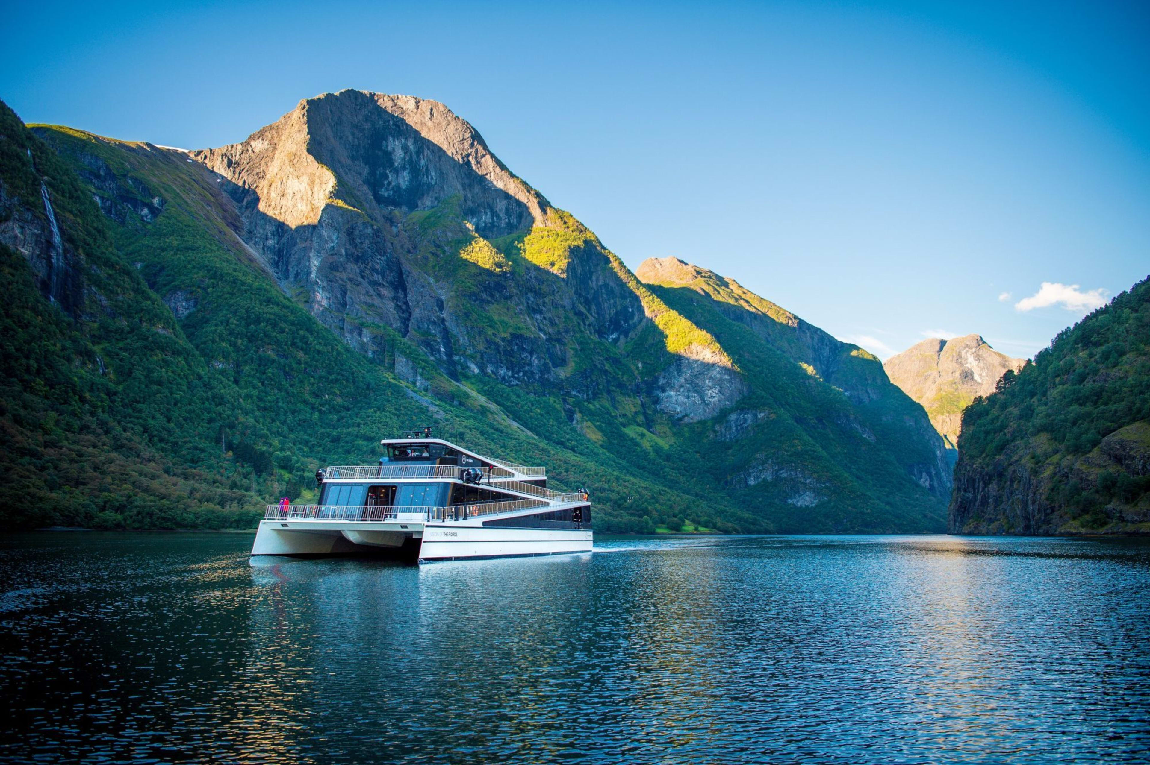 Die Vision der Fjorde führt durch den wunderschönen Nærøyfjord und die sonnenbeschienenen grünen Berge.