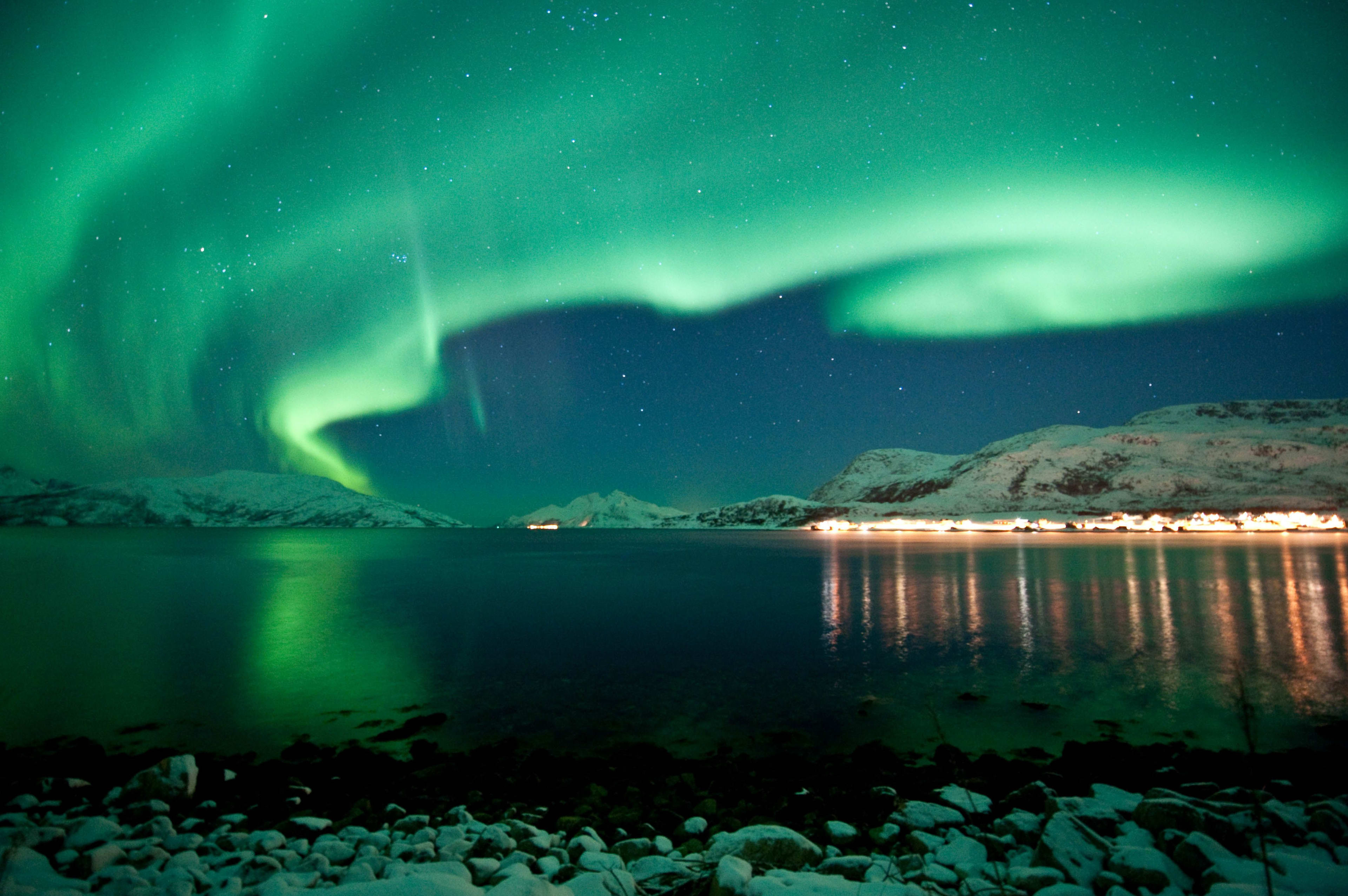 Nordlicht über Fjord und Bergen bei sternklarer Nacht.