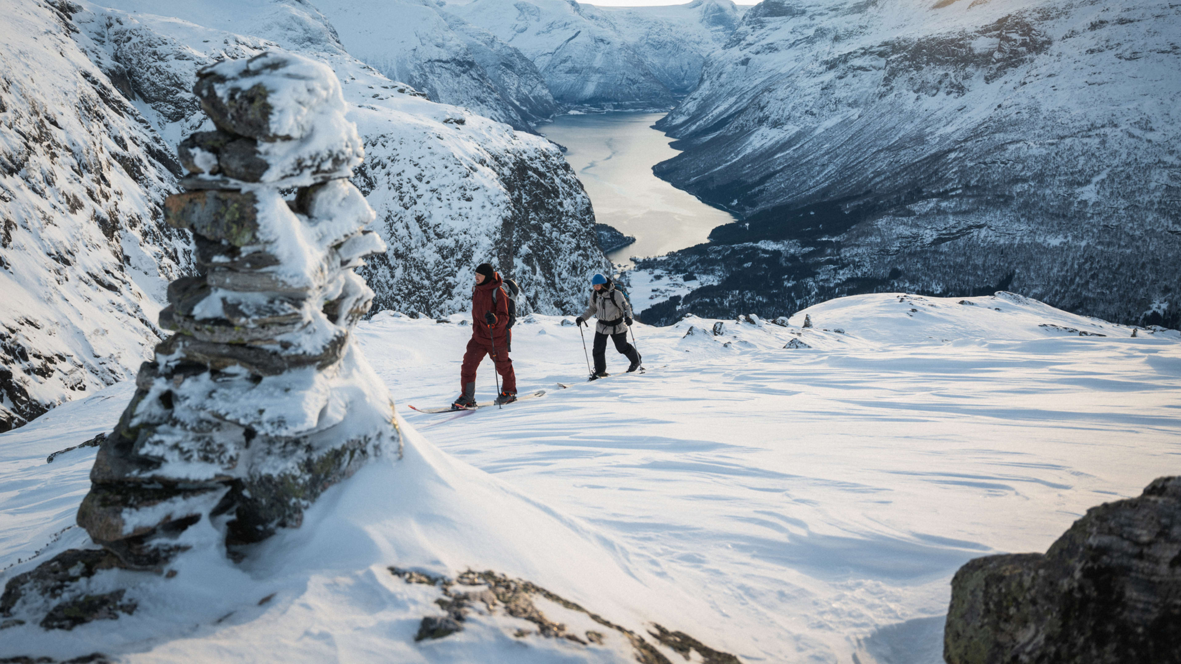 Zwei Personen auf Skitour mit Blick auf den Nordfjord im Winter