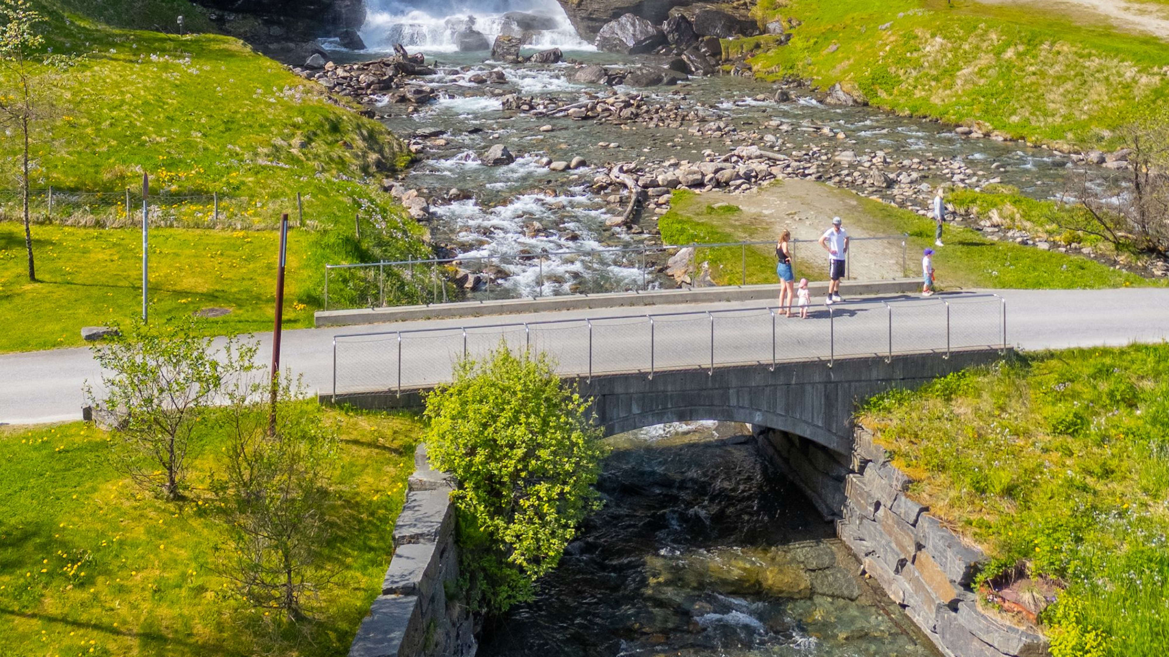 Blick auf den Steinsdalsfossen-Wasserfall von der Hauptstraße, mit dem barrierefreien Weg, der Besucher hinter den 50-Meter-Wasserfall führt