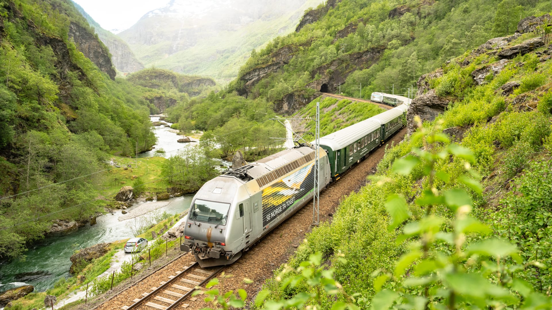 Flåmsbana tog på vei oppover fjellsiden fra Flåm til Myrdal stasjon med utsikt over Flåmsdalen