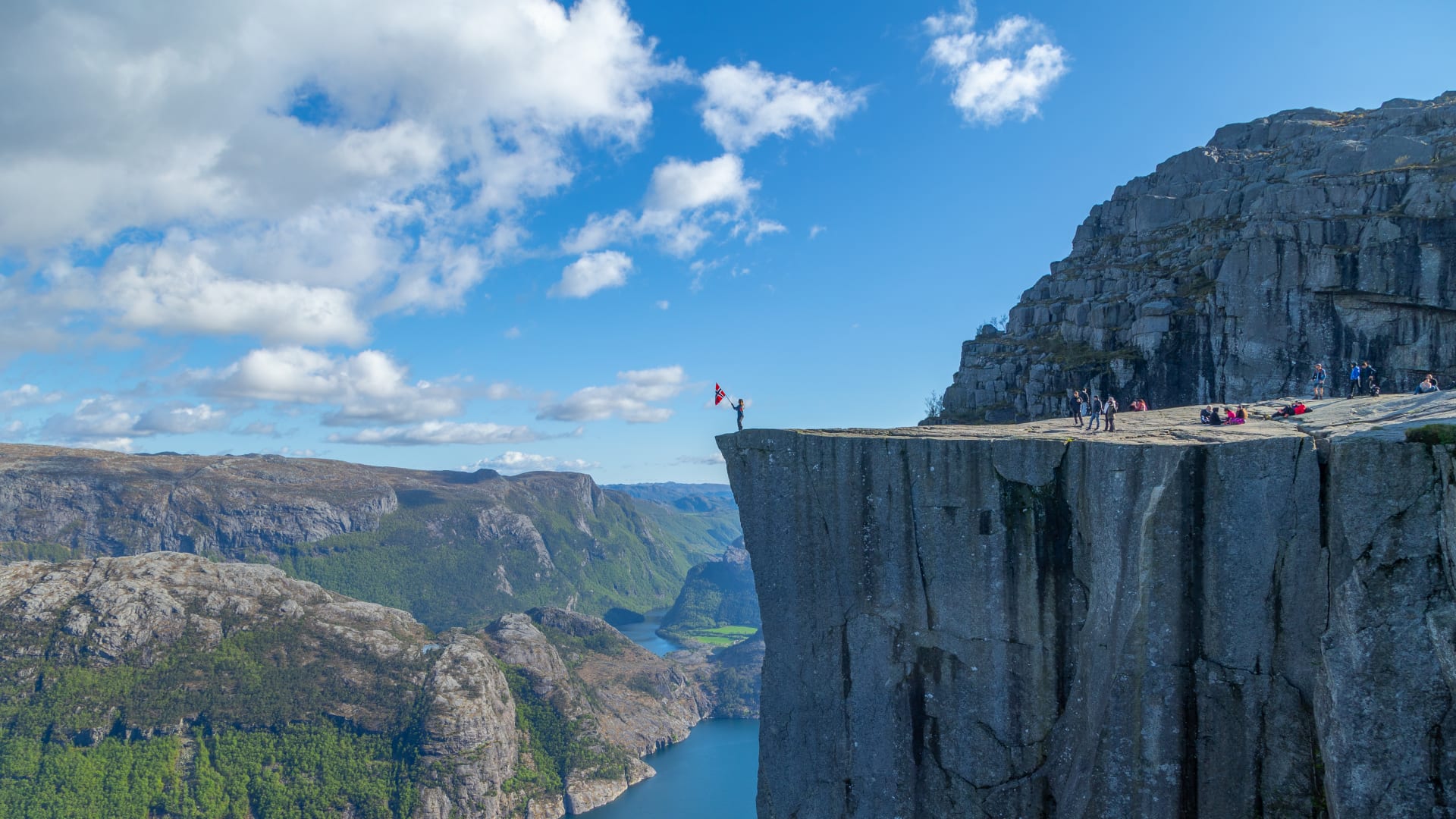 Wanderer auf dem Preikestolen mit Blick hinunter auf den Lysefjord