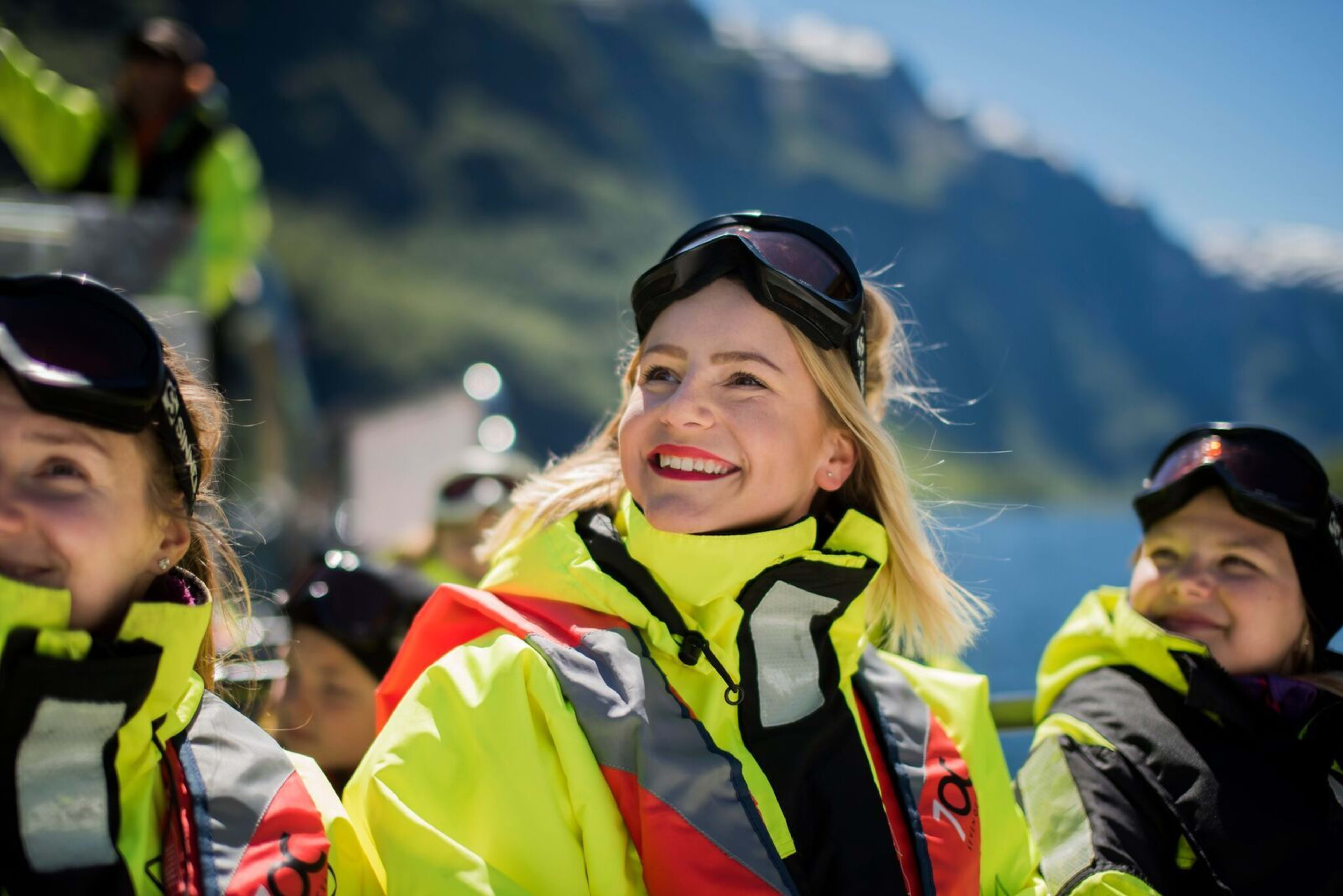En smilende kvinne sitter i en solfylt båt på fjordsafari på Nærøyfjorden fra Flåm.