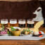 Probierteller mit Muscheln, Brot, Fleisch mit Kräutern, cremigen Gerichten, Schokoladendessert und Craft-Cider in rustikalem Ambiente.