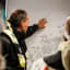 Guide explaining RIB boat tour route on map in Ålesund before departure through dramatic coastal islands and fjord landscape