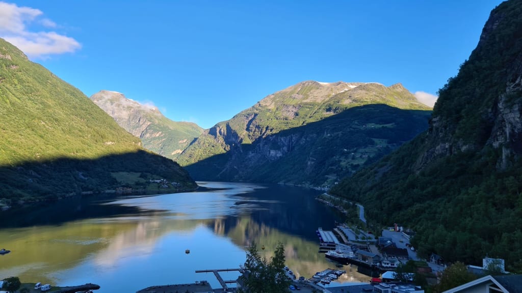 Geiranger og Geirangerfjorden oversikt med dramatiske fjell og UNESCO verdensarv