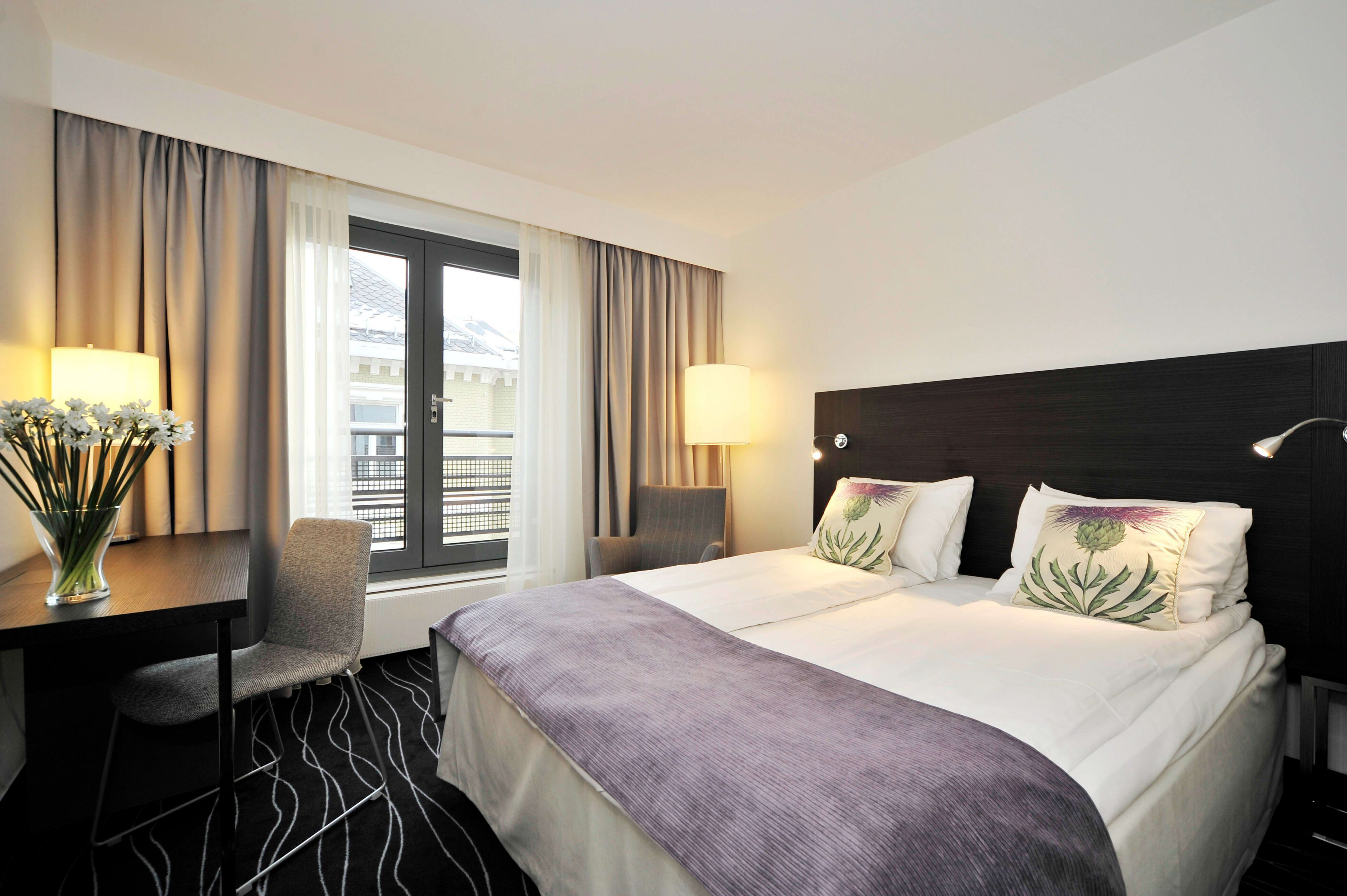 Elegant superior rom på Thon Hotel Cecil Oslo med dobbeltseng arbeidsområde blomster og byutsikt