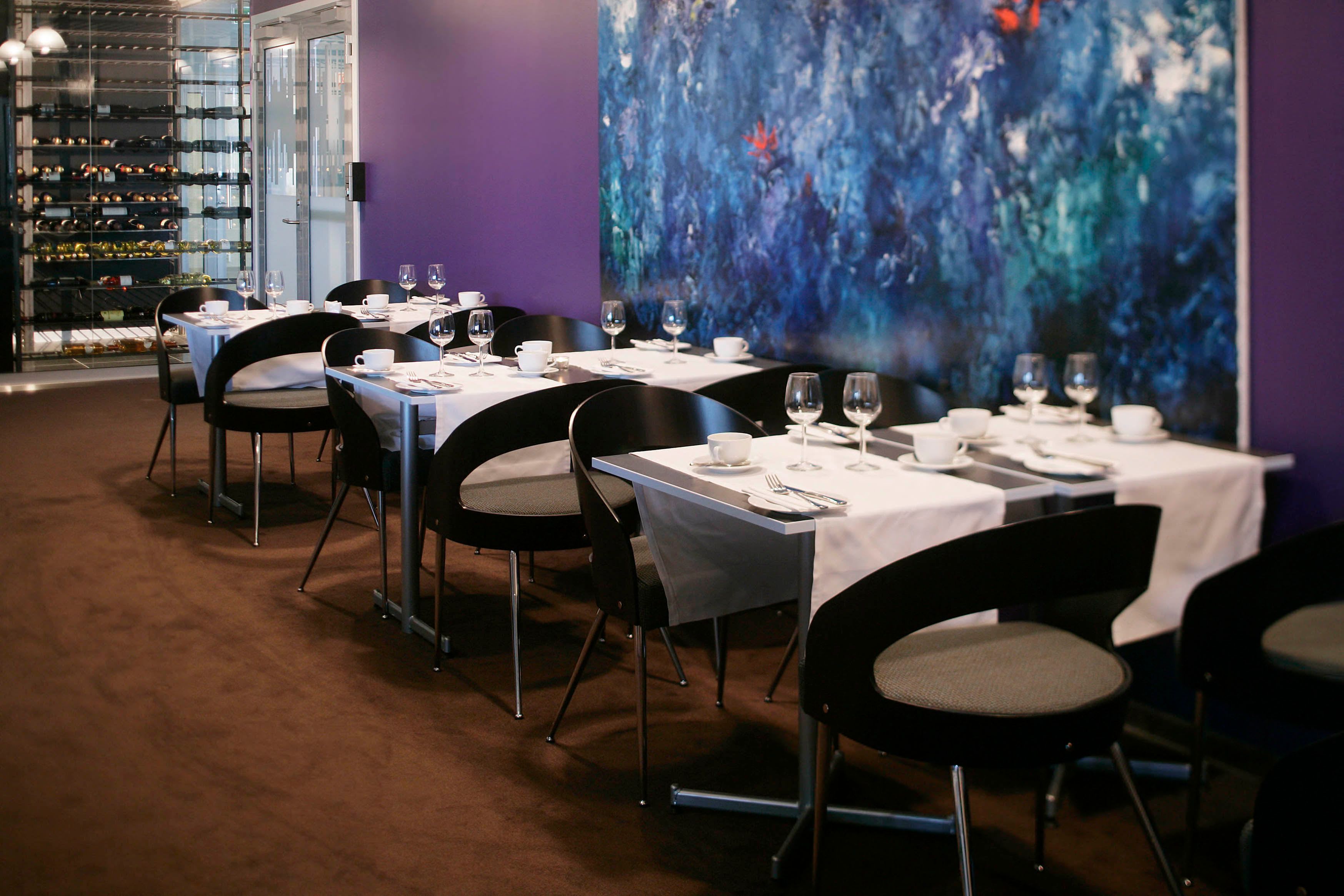 Modern restaurant at Thon Hotel Oslo Airport featuring purple decor and contemporary wall art