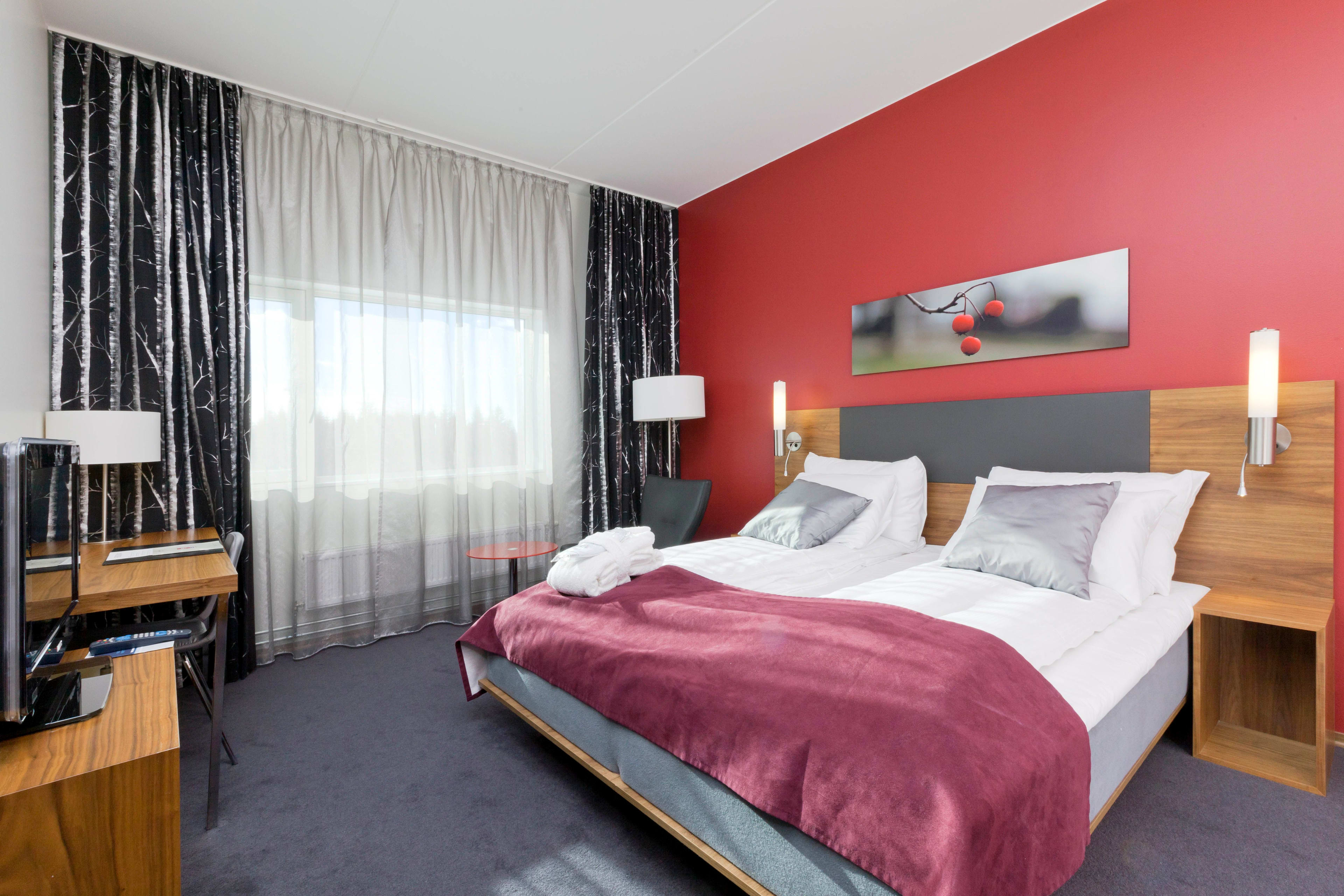 Thon Hotel Oslo Airport suite with double bed, modern red black decor and Oslo city views