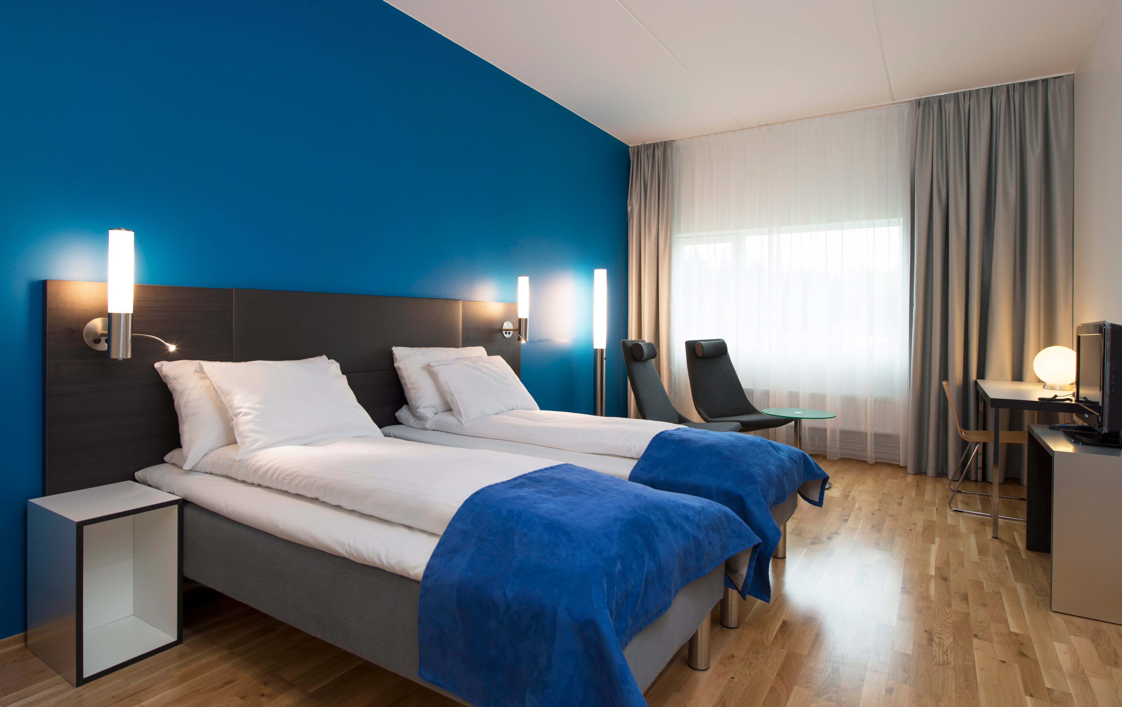 Bright double room at Thon Hotel Oslo Airport with blue interior, TV, and work desk - modern accommodation