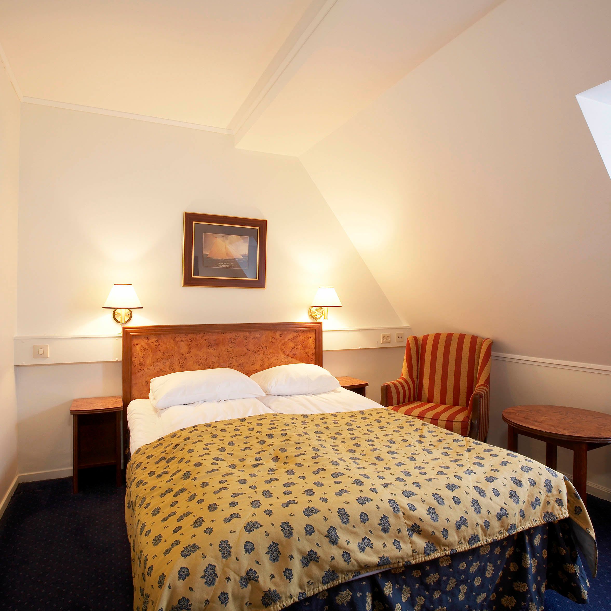 Modern double room at Thon Hotel Trondheim with queen bed and warm golden yellow interior