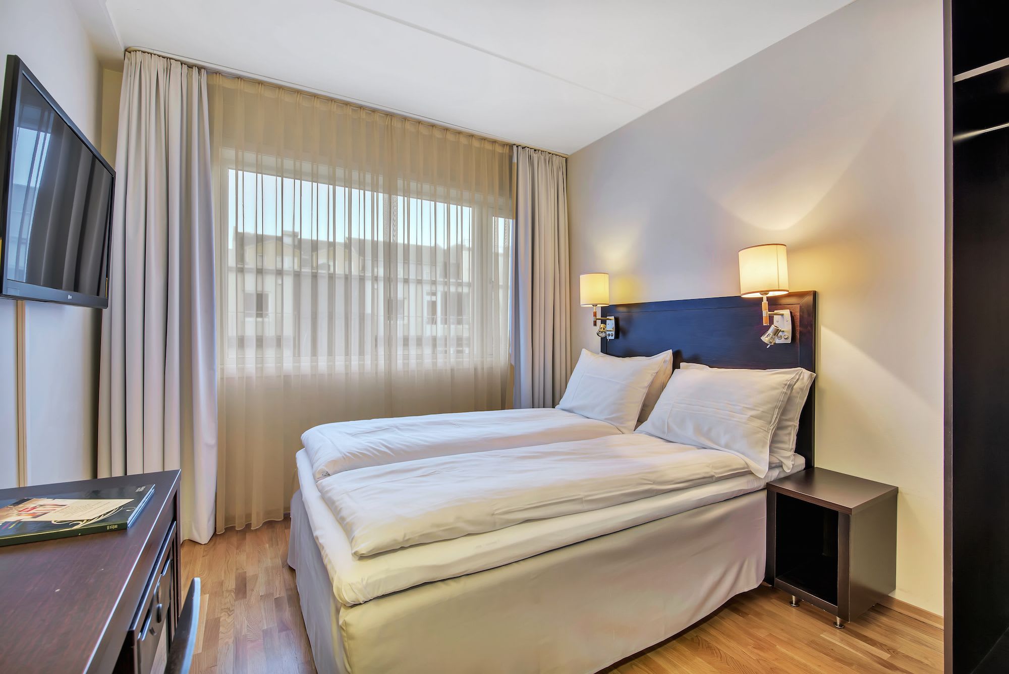 Modern double room at Thon Hotel Polar featuring queen bed, elegant beige furnishings and Tromsø city views