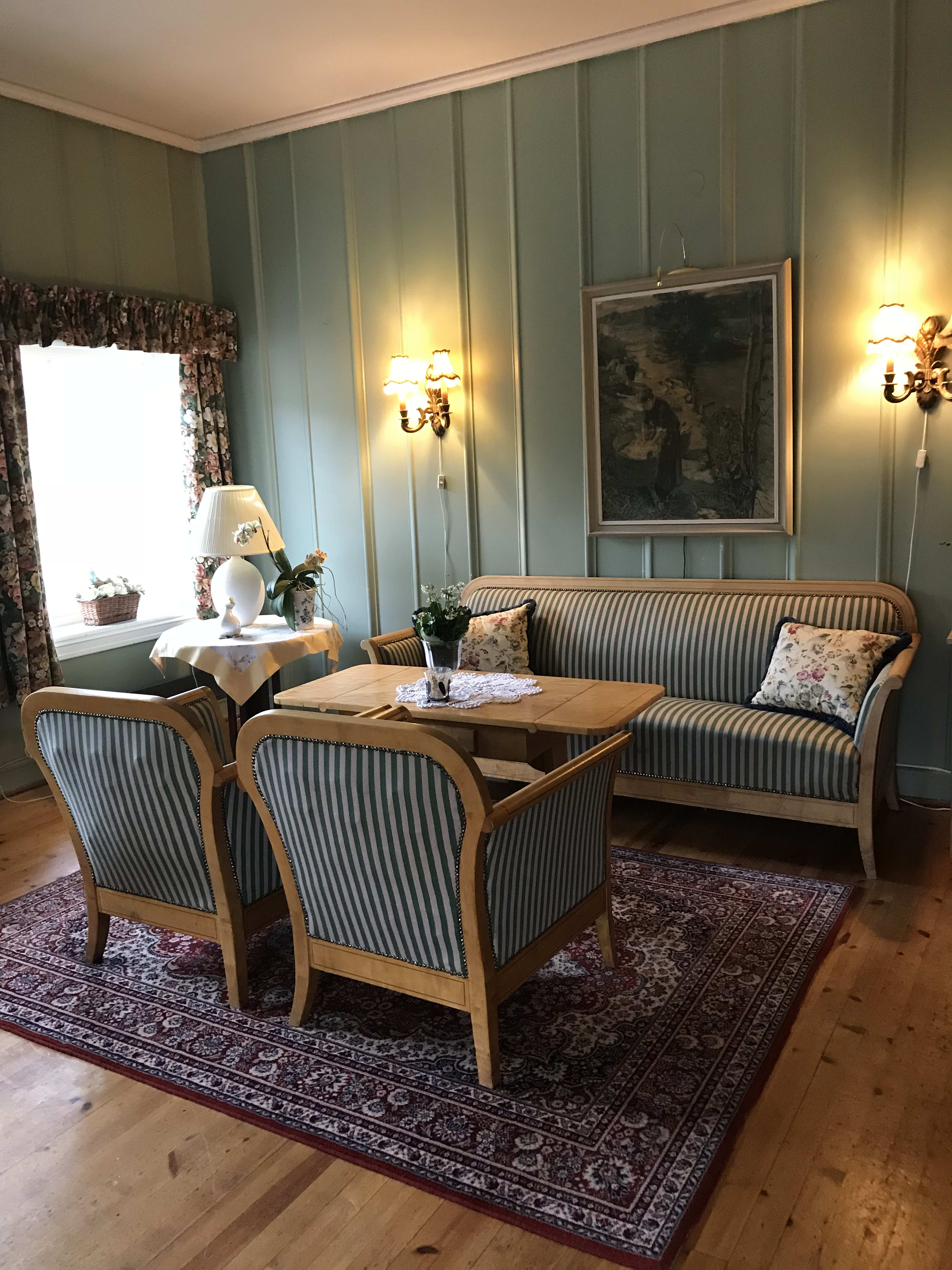 Cozy living room at Vatnahalsen Høyfjellshotell featuring comfortable sofas, warm lamps, and traditional mountain lodge decor.