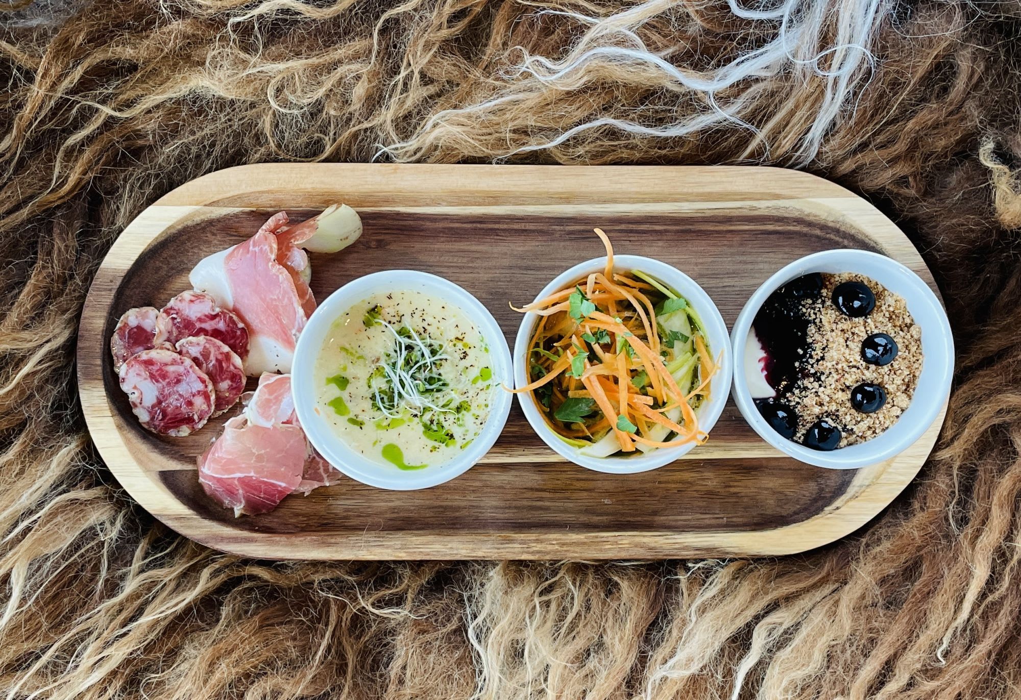 Treetallerken med spekemat, kremet suppe med urter, grønnsakssalat og dessert med blåbær og smuldre.