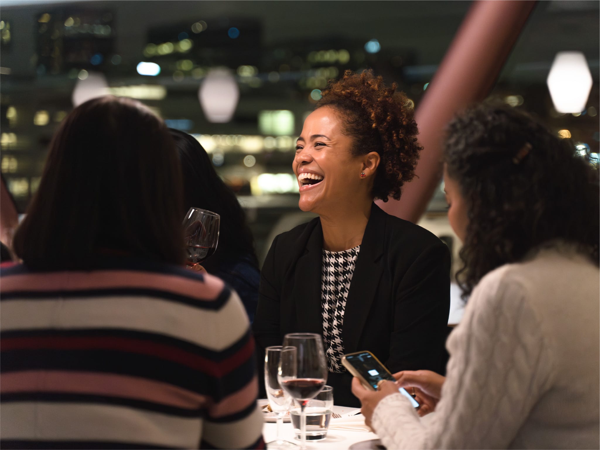 Kvinne nyter middag med byutsikt fra cruisebåt